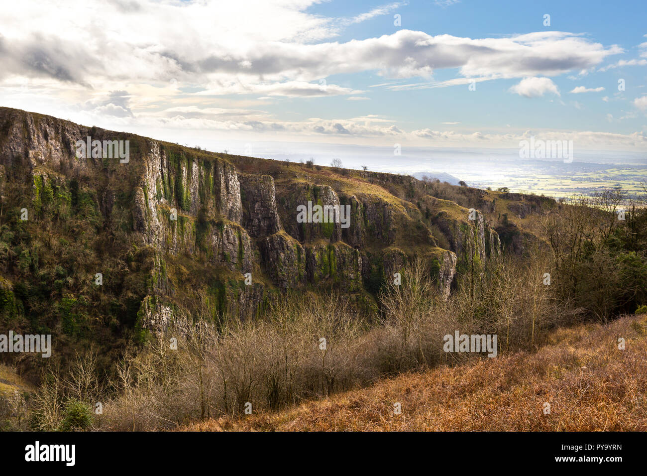 Vista dalla cima del Cheddar Gorge guardando attraverso il paesaggio con le nuvole nel cielo blu e alberi Foto Stock