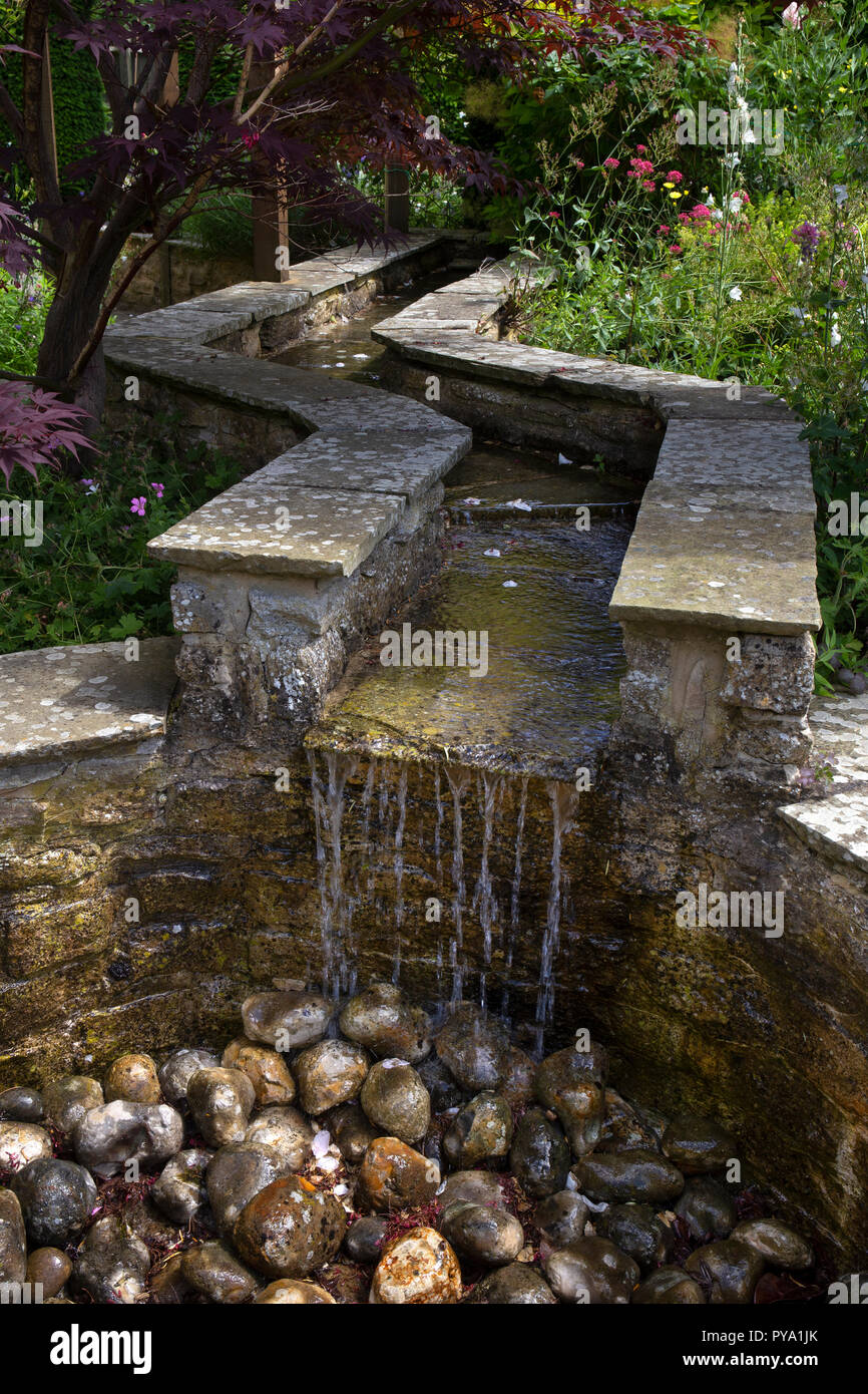 Acqua di pietra con funzione di ciottoli in un giardino inglese , inghilterra, europa Foto Stock
