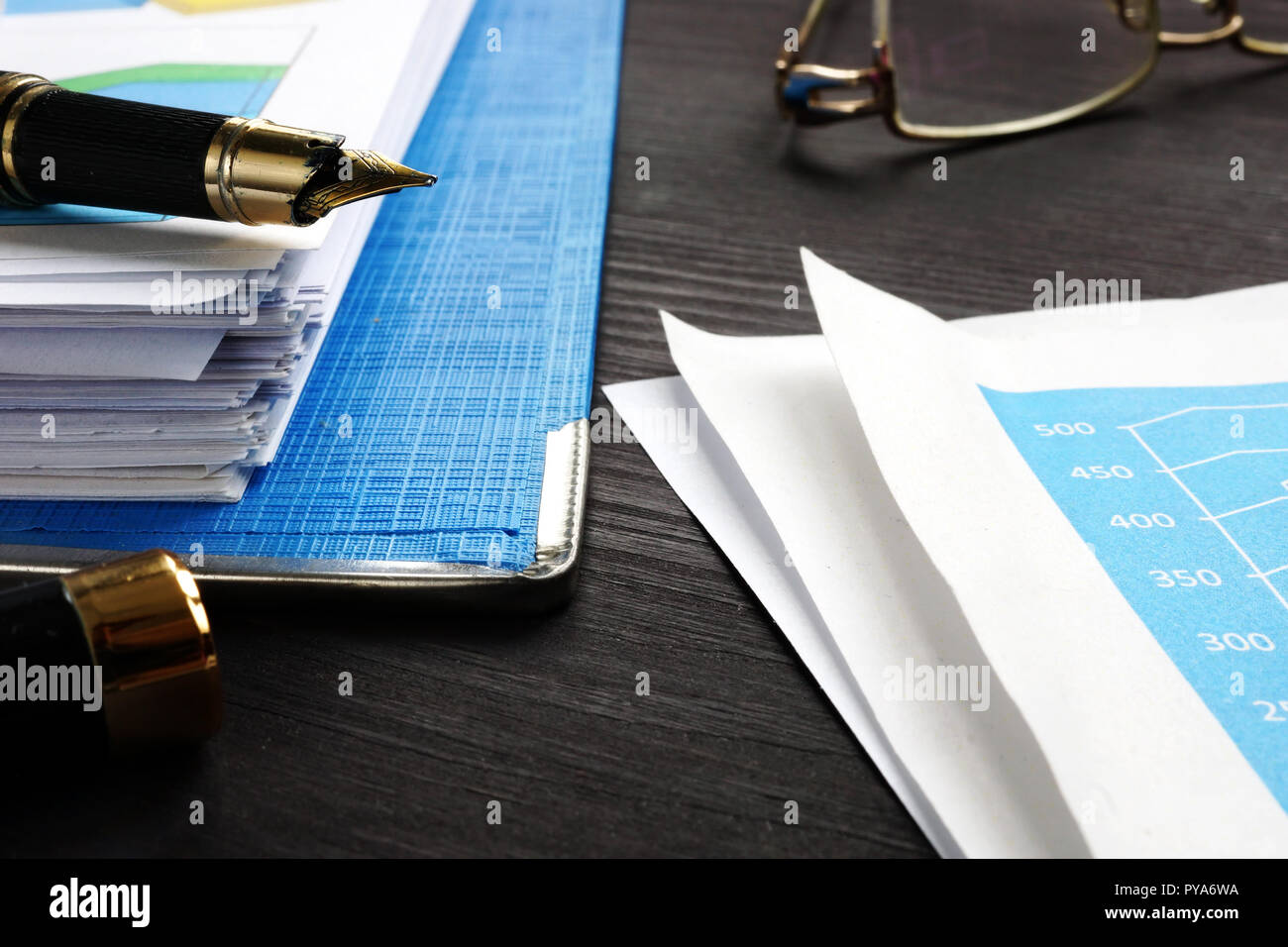 Relazione finanziaria e documenti aziendali sulla scrivania in ufficio. Foto Stock