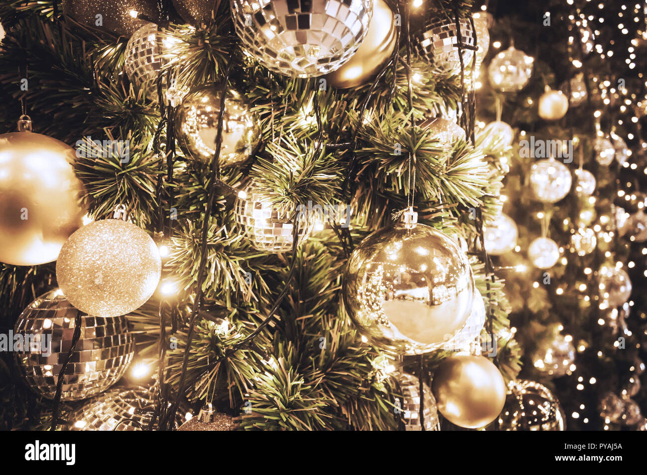 Albero di natale con sfera in oro e luci bokeh sfondo. Xmas abstract close up con decorazioni incandescente all'esterno. Foto Stock