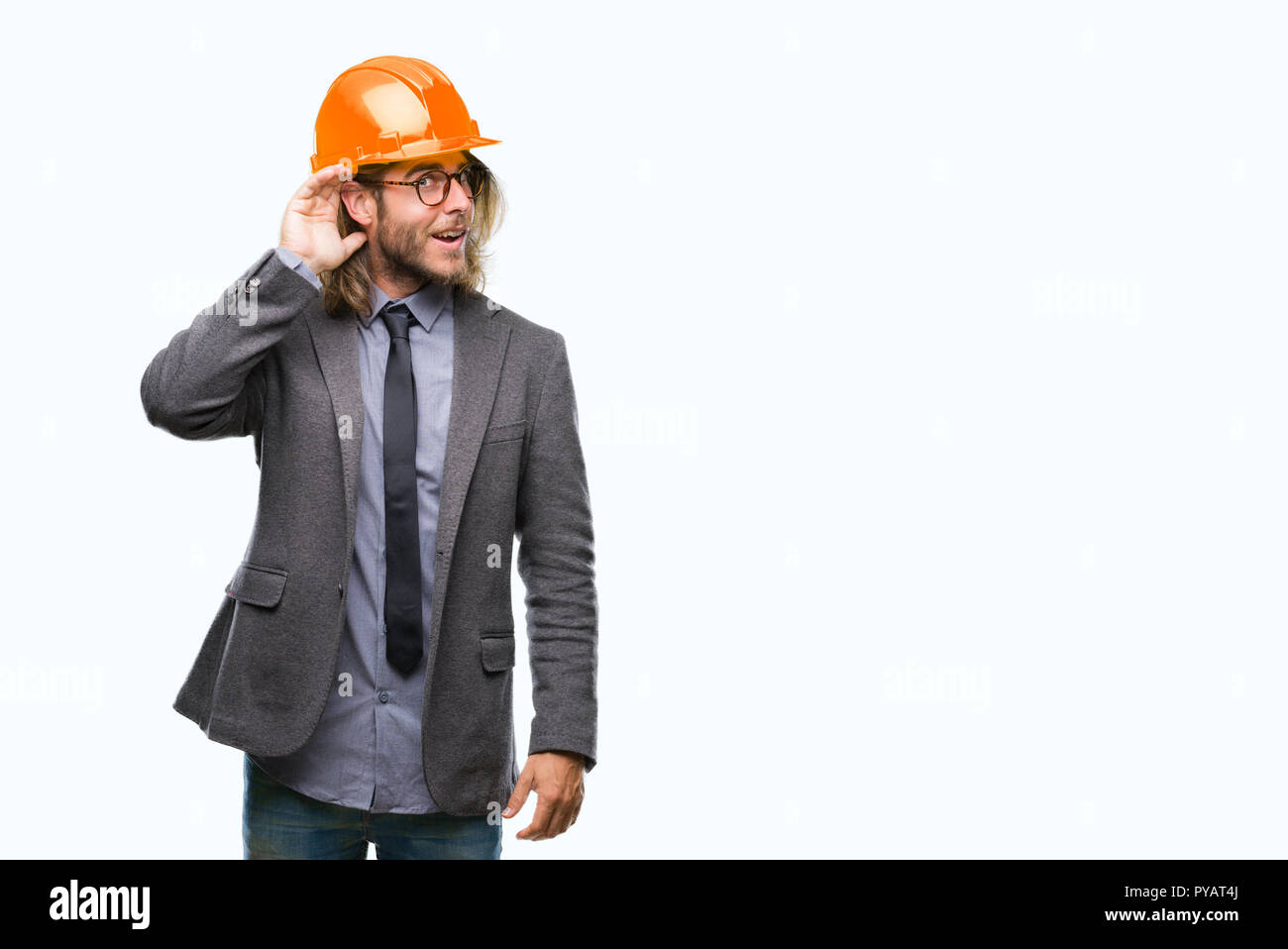 Giovane bello architec uomo con capelli lunghi che indossa il casco di sicurezza su sfondo isolato sorridente con la mano sul orecchio in ascolto di un audizione di rumor o Foto Stock Giovane bello architec uomo con capelli lunghi che indossa il casco di sicurezza su sfondo isolato sorridente con la mano sul orecchio in ascolto di un audizione di rumor o Foto Stock