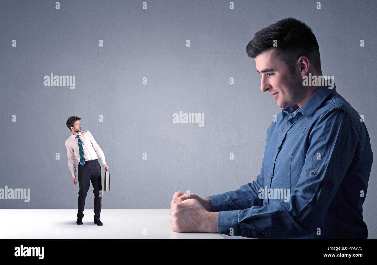 Giovane imprenditore professionale essendo arrabbiato con un altro imprenditore in miniatura Foto Stock