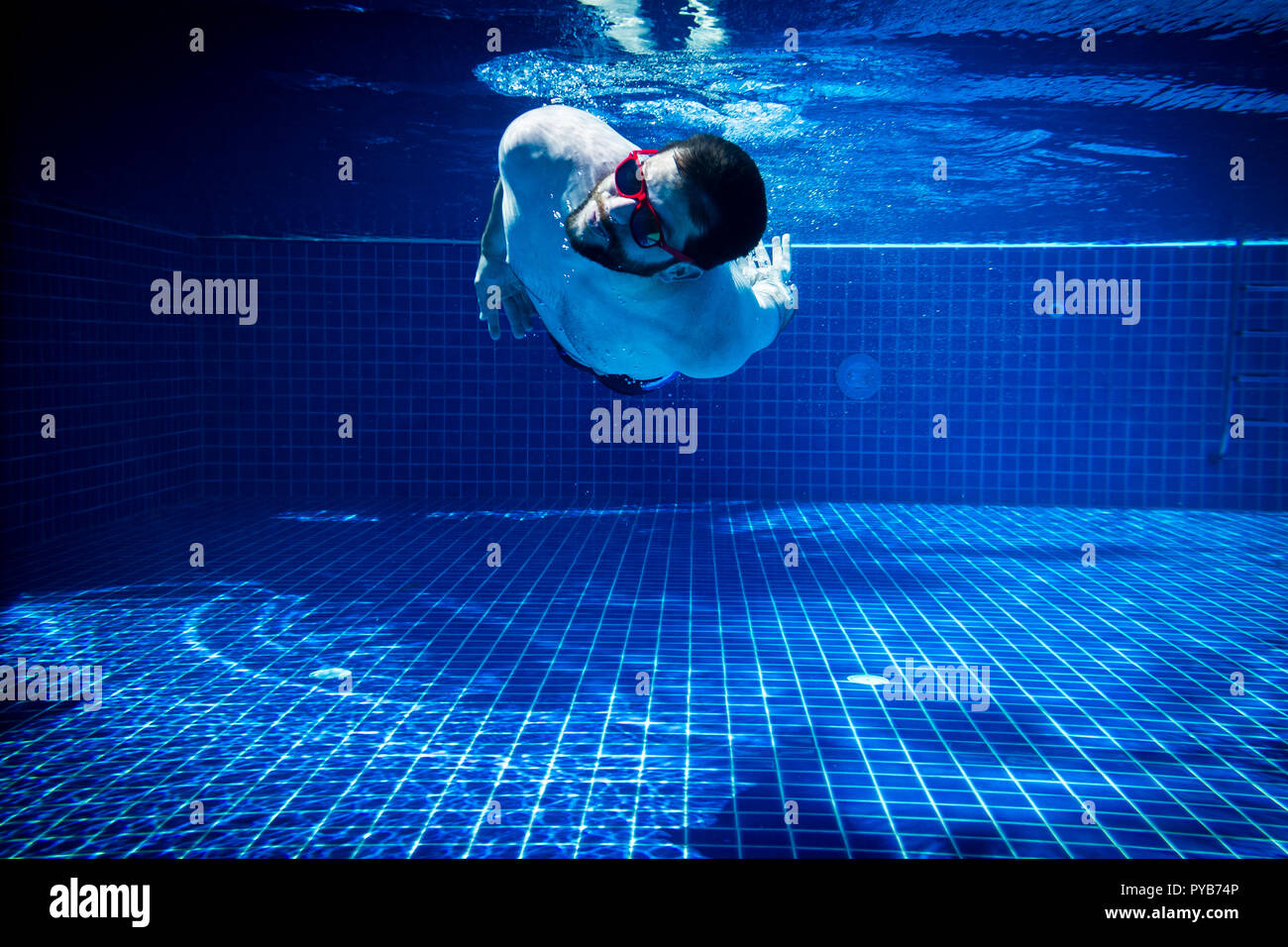 Giovane con occhiali da sole godendo della piscina abstract divertimento estivo nuoto subacqueo salto sfondo immersioni Foto Stock