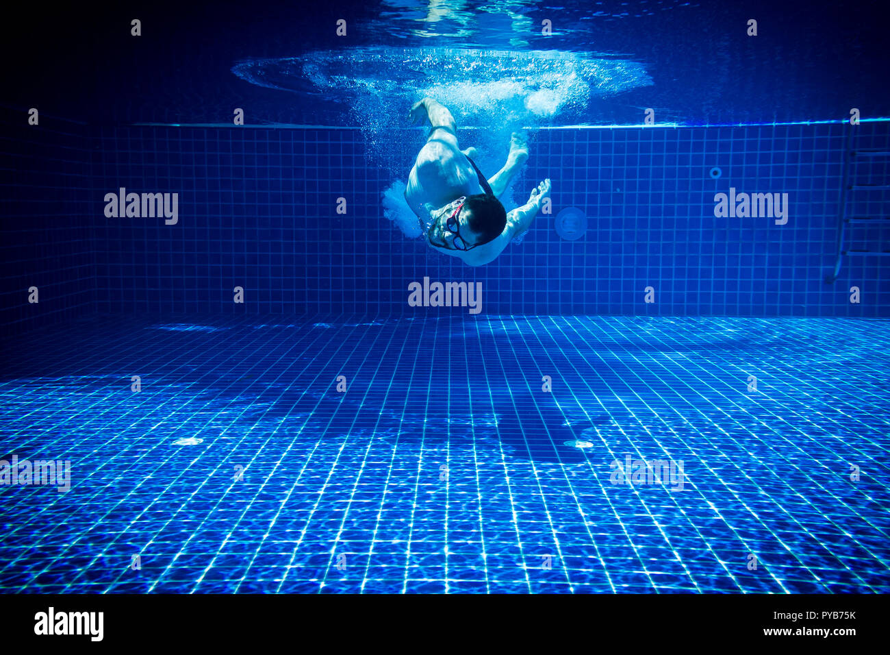 Giovane con occhiali da sole godendo della piscina abstract divertimento estivo nuoto subacqueo salto sfondo immersioni Foto Stock