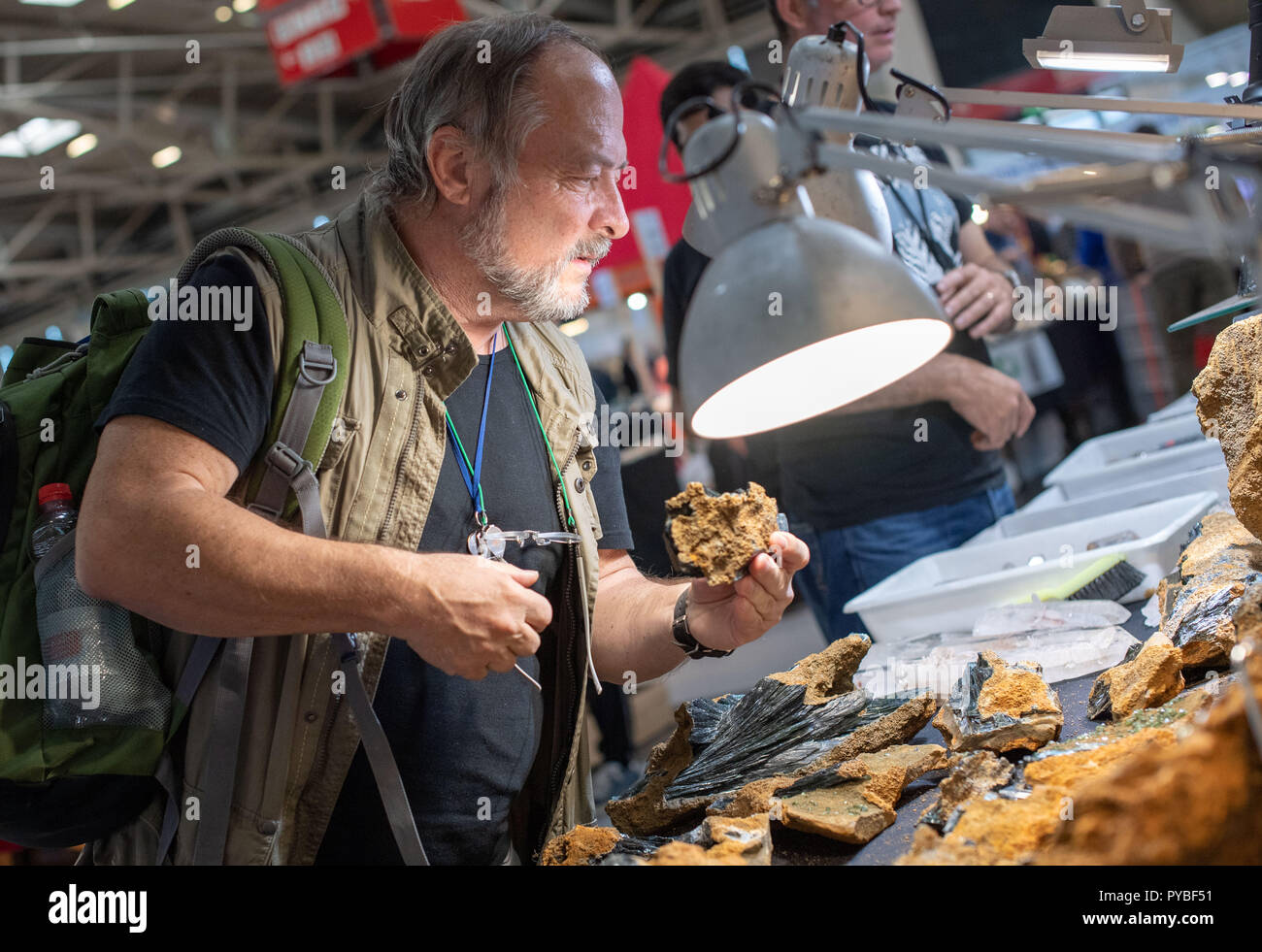 Monaco di Baviera, Germania. 26 ott 2018. 26 ottobre 2018, Germania, Monaco di Baviera: Frank Morgenstern, collezionista di minerali, guarda ai vari pezzi di ametista presso un concessionario tabella durante il minerale di giorni. Il minerale di giorni sono una fiera di minerali, fossili e pietre preziose che dura fino al 28 Ottobre. Credito: Lino Mirgeler/dpa/Alamy Live News Foto Stock