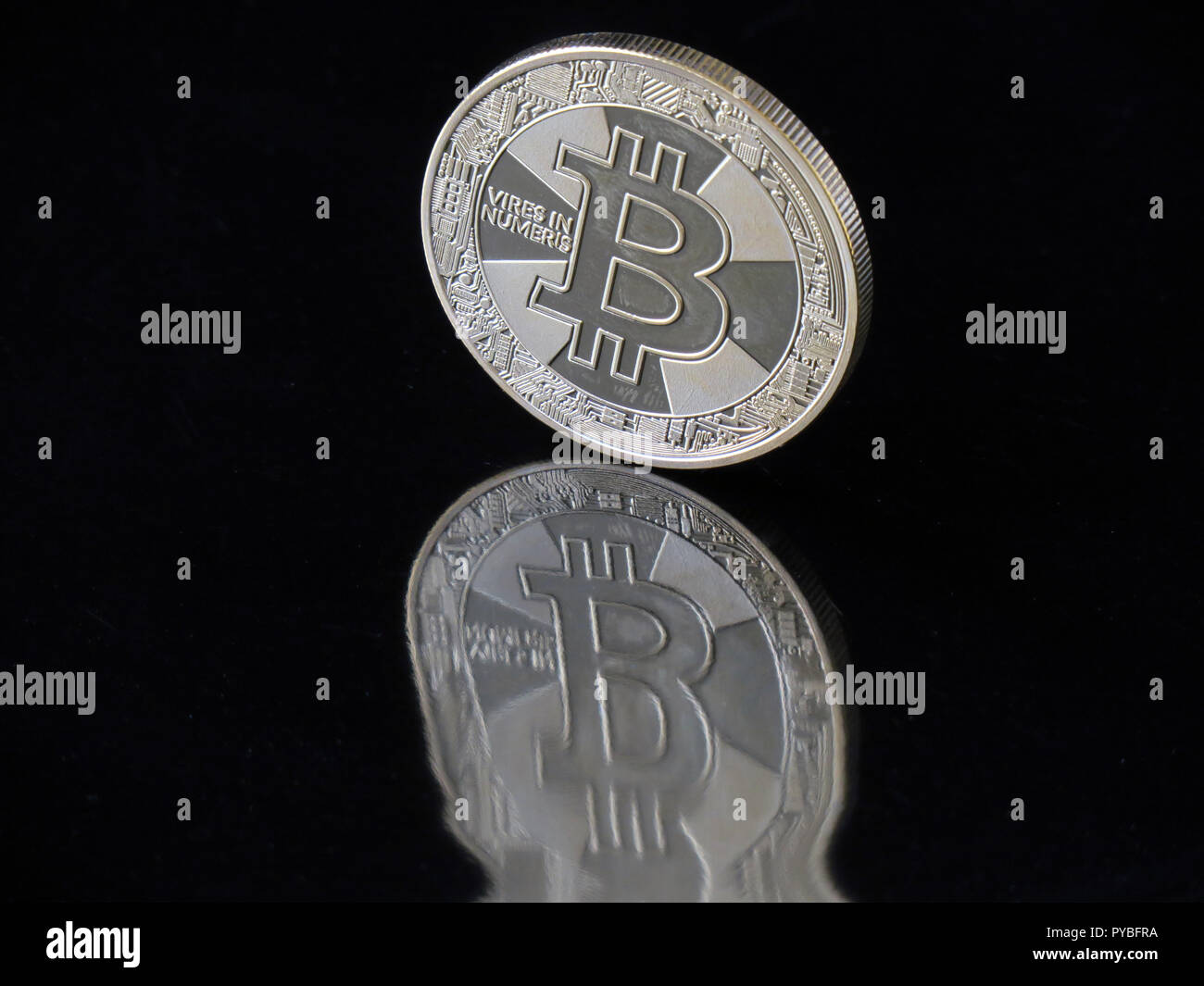 Berlino, Germania. Il 30 agosto, 2018. Il 30 agosto 2018, Germania Berlino: una moneta Bitcoin con l impronta "eccesso di potere in Numeris' (forza in numeri) riflette distorta in un'area nera. La valuta digitale è stata intorno per dieci anni e ora è basato su blockchains (catene di blocchi di dati in cui le unità di Bitcoin sono generati in operazioni matematiche su computer. Credito: Soeren Stache/dpa-Zentralbild/ZB/dpa/Alamy Live News Foto Stock