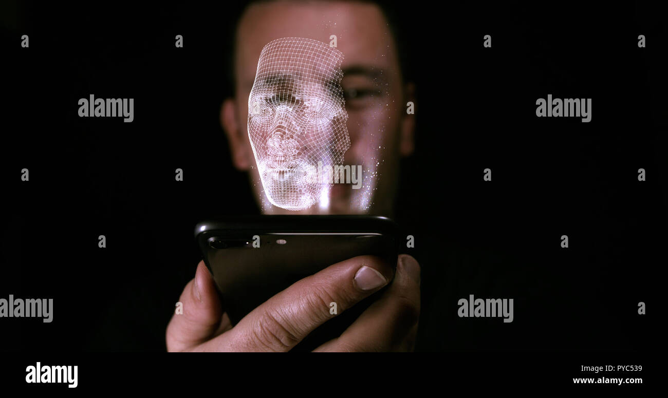 Azienda maschio su un dispositivo digitale con un ologramma tridimensionale di una copia del suo volto. Il riconoscimento facciale e il concetto di identità Foto Stock