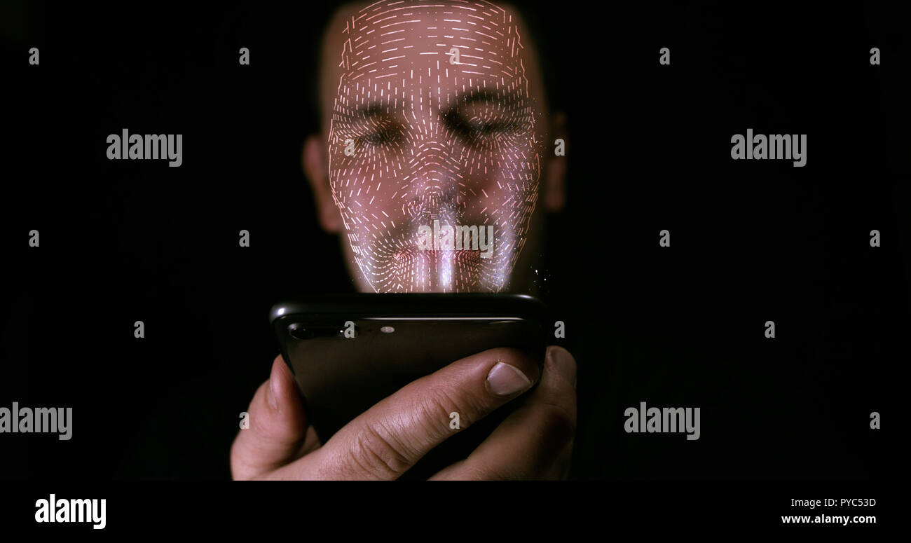 Maschio utilizzando il suo smart phone con il riconoscimento facciale sbloccare. Il mesh 3D stampa è proiettata sul suo volto. Foto Stock