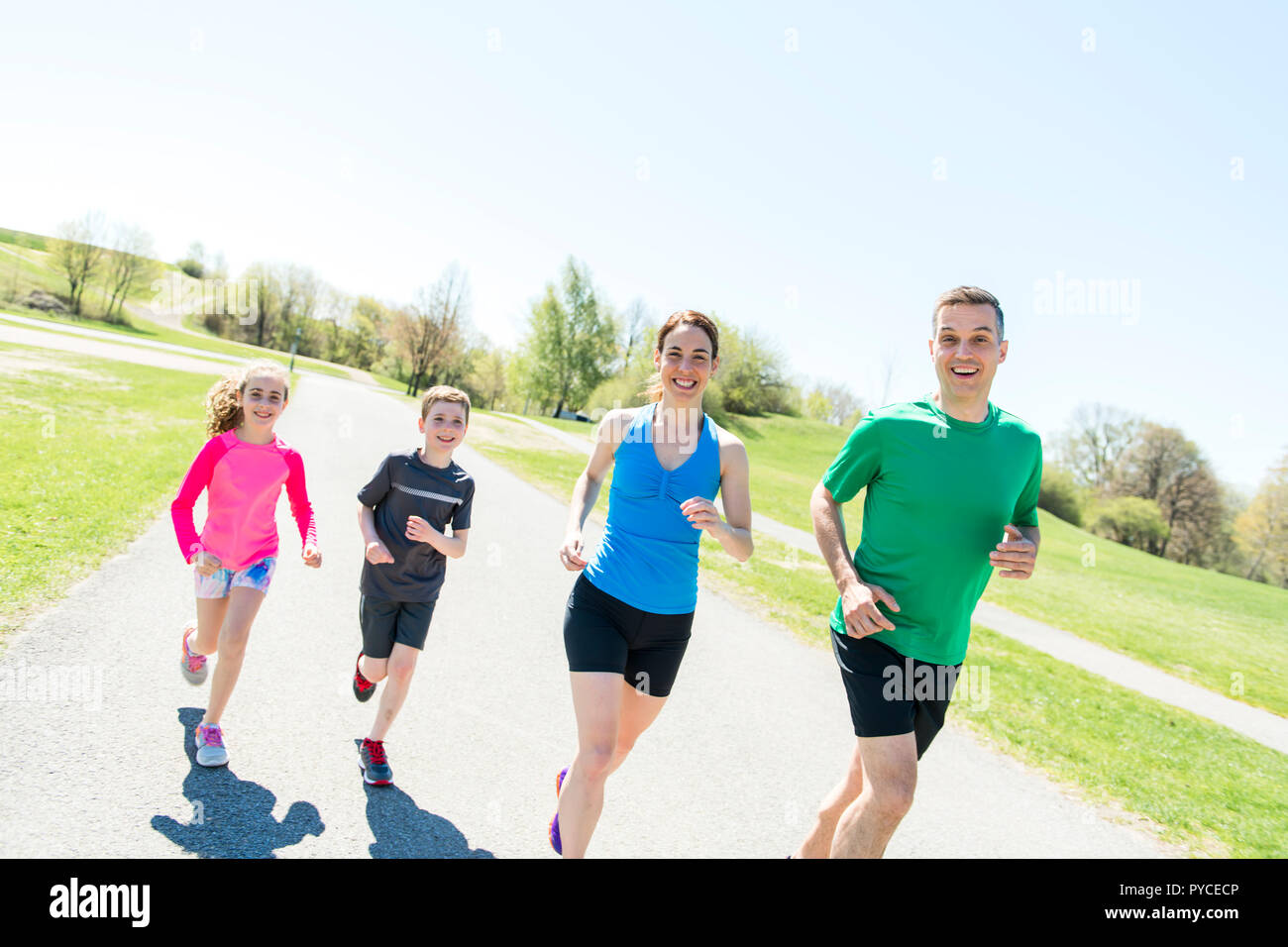 I genitori con bambini sport correndo insieme all'esterno Foto Stock