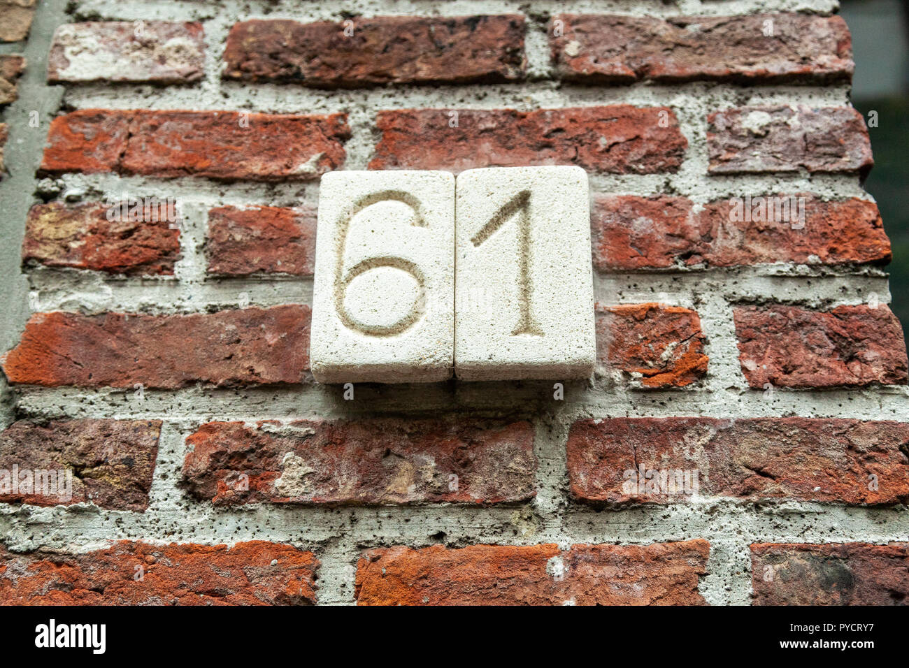 Numero di casa sessantuno 61 scolpiti in pietra bianca incollata a mattoni in Svezia Foto Stock