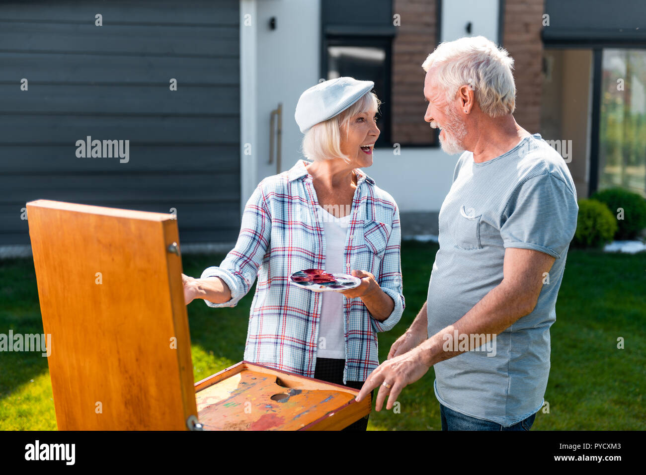 Amorevole marito barbuto proveniente e visita di sua moglie disegno in giardino Foto Stock