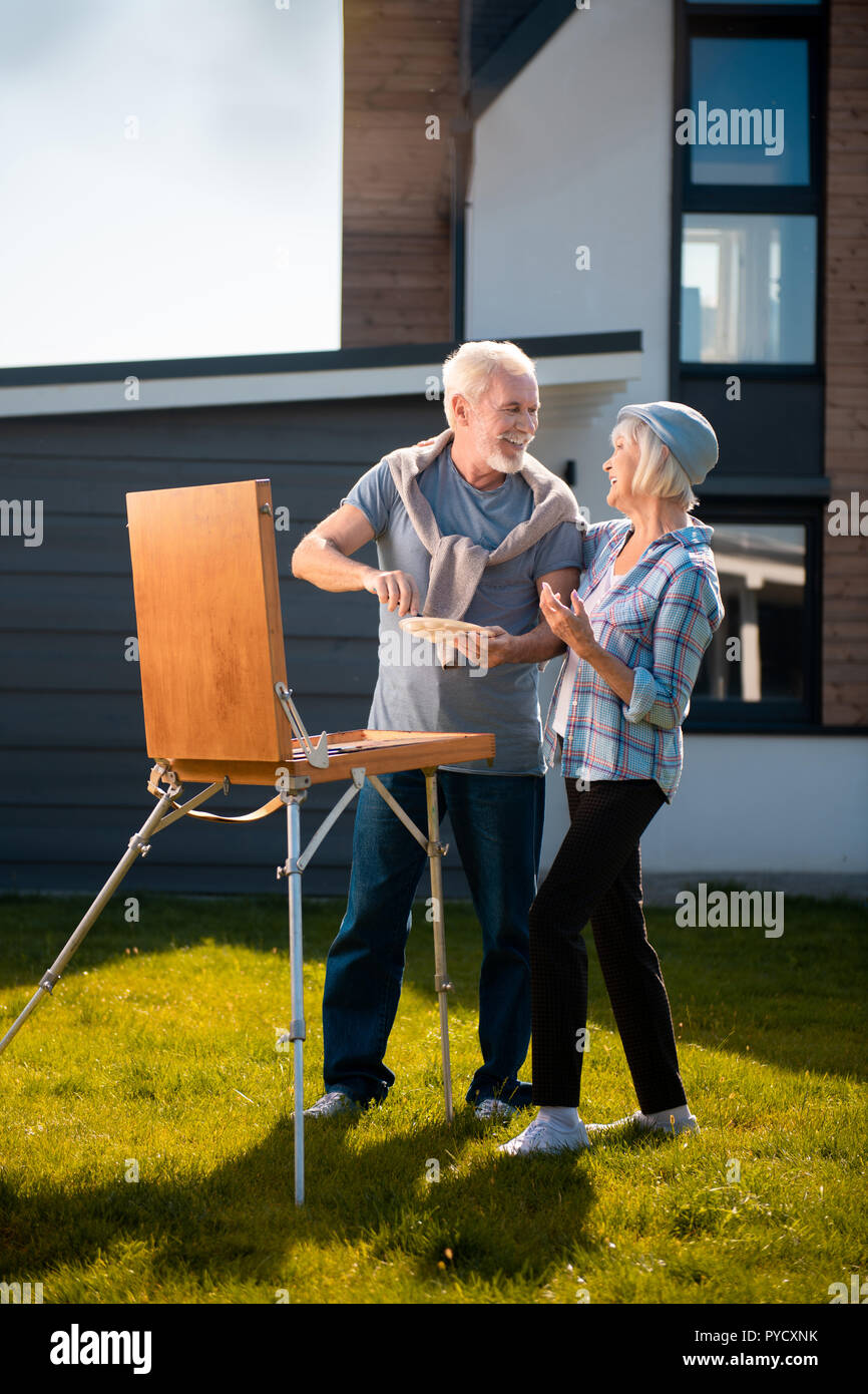 Coppia di pensionati uomo e donna disegno natura insieme mentre in piedi in giardino Foto Stock