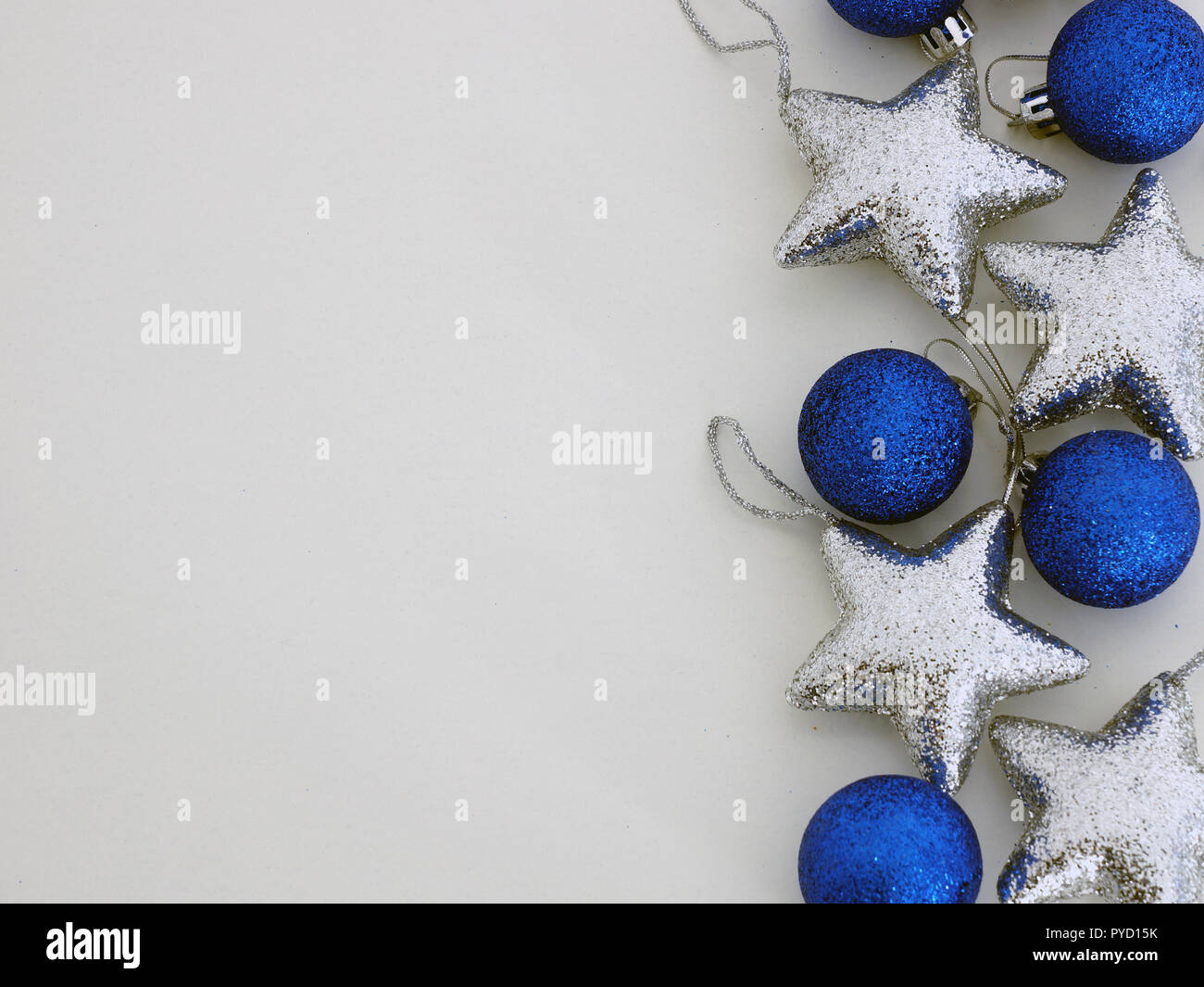 Le decorazioni di Natale palle blu e argento stelle su sfondo grigio. Decorazione di natale. Foto Stock