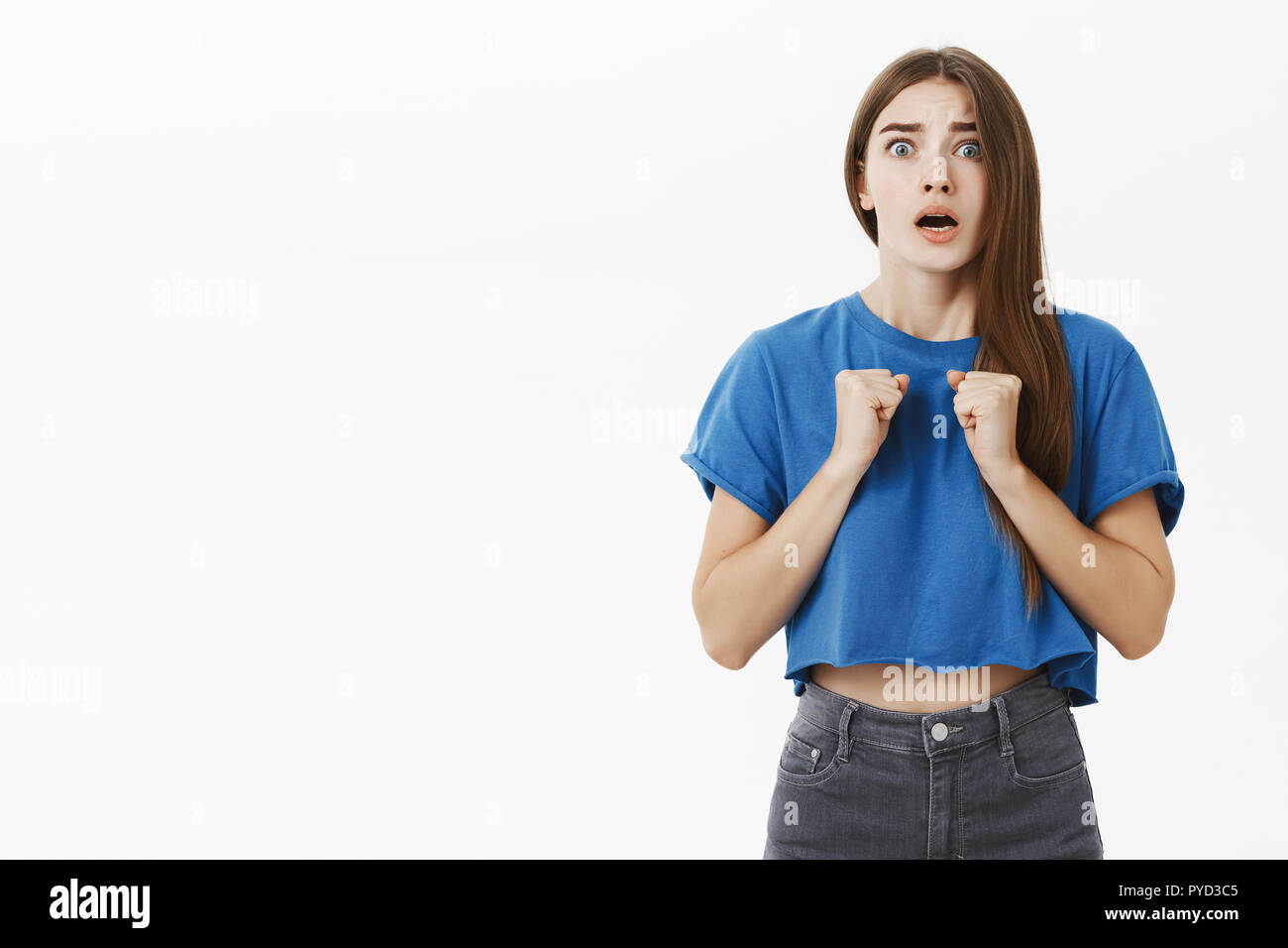 Donna di essere preoccupato per l'amico mettersi in pericolo permanente senza fiato storditi e intensi stringendo i pugni nervosamente vicino al petto di aprire bocca, sensazione di empatia e di ansia su sfondo grigio Foto Stock