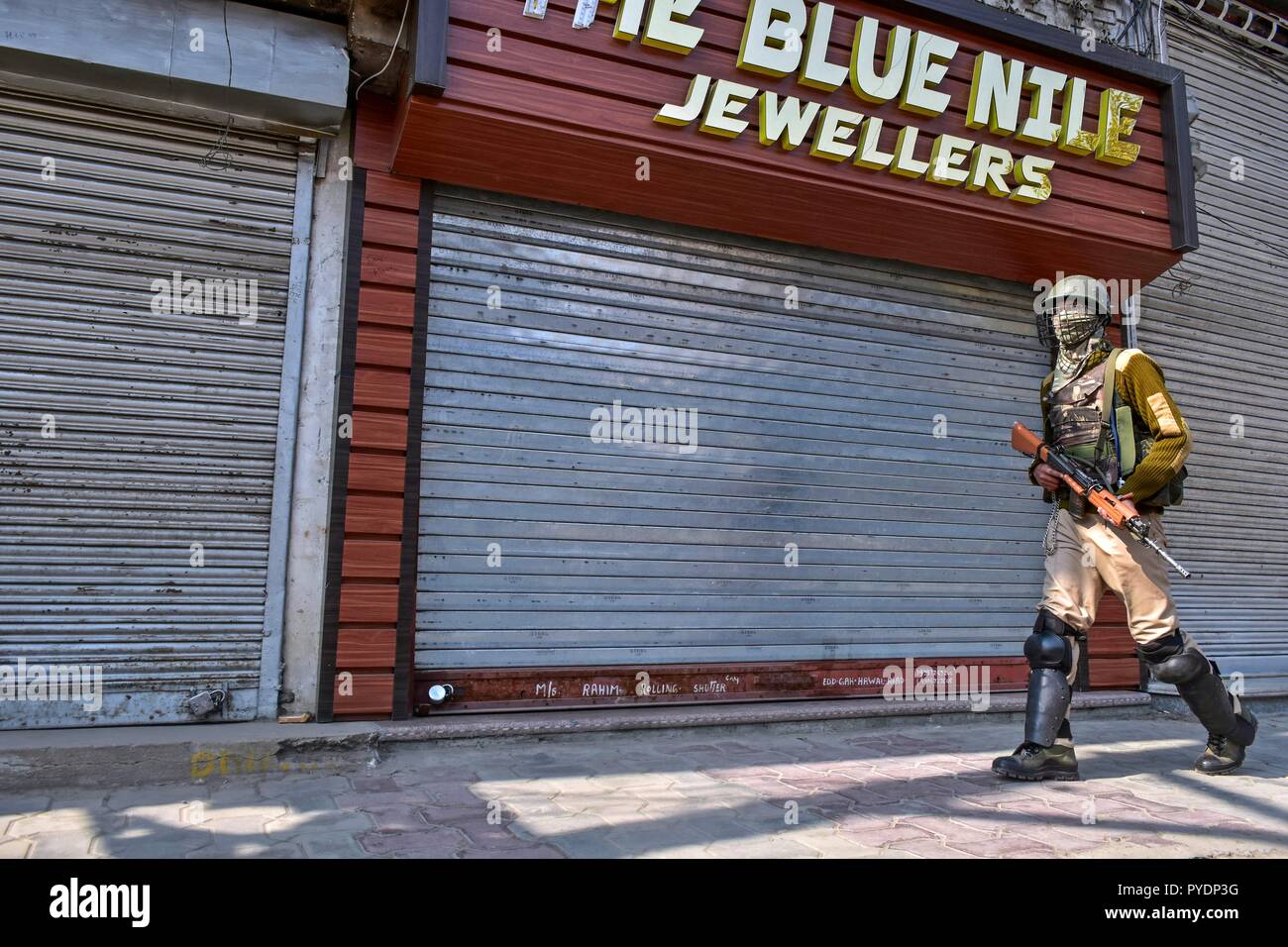 Un soldato di paramilitari visto pattugliano la strada durante il coprifuoco. Valle del Kashmir è sotto controllo il coprifuoco in risposta alla resistenza islamica leader chiamato la popolazione musulmana per contrassegnare 27 Ottobre come una "giornata nera" del Kashmir mentre le autorità indiane sono celebrato come il 71esimo anniversario del dispiegamento delle truppe in Srinagar. Foto Stock
