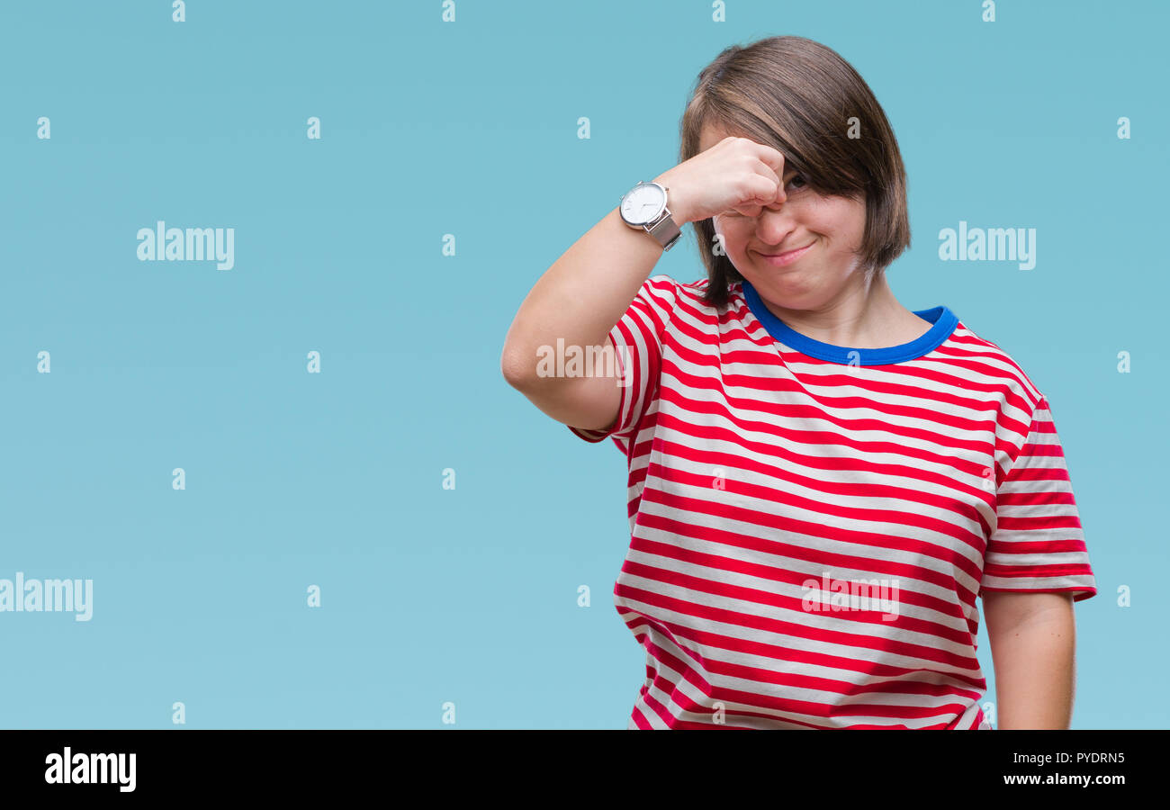 Giovane donna adulta con la sindrome di down su sfondo isolato stanco strofinando il naso e gli occhi sensazione di stanchezza e mal di testa. Stress e frustrazione concept Foto Stock