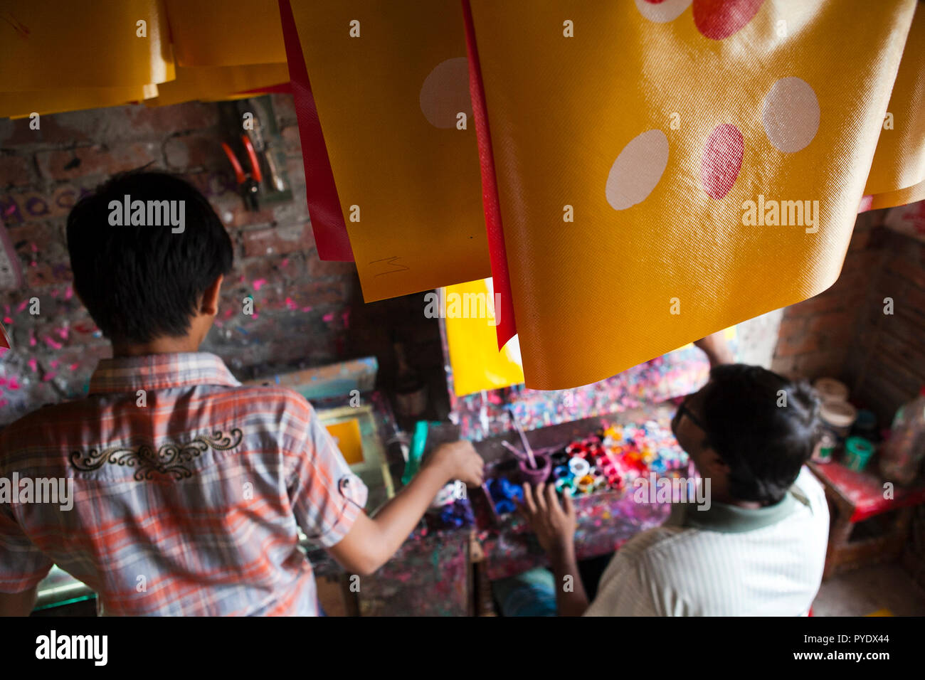Proshanto Kumar Das, figlio di Raj Kumar Das, meglio noto come RK Das, uno della prima generazione di artisti rickshaw in Bangladesh, è impegnato in una pittura Foto Stock