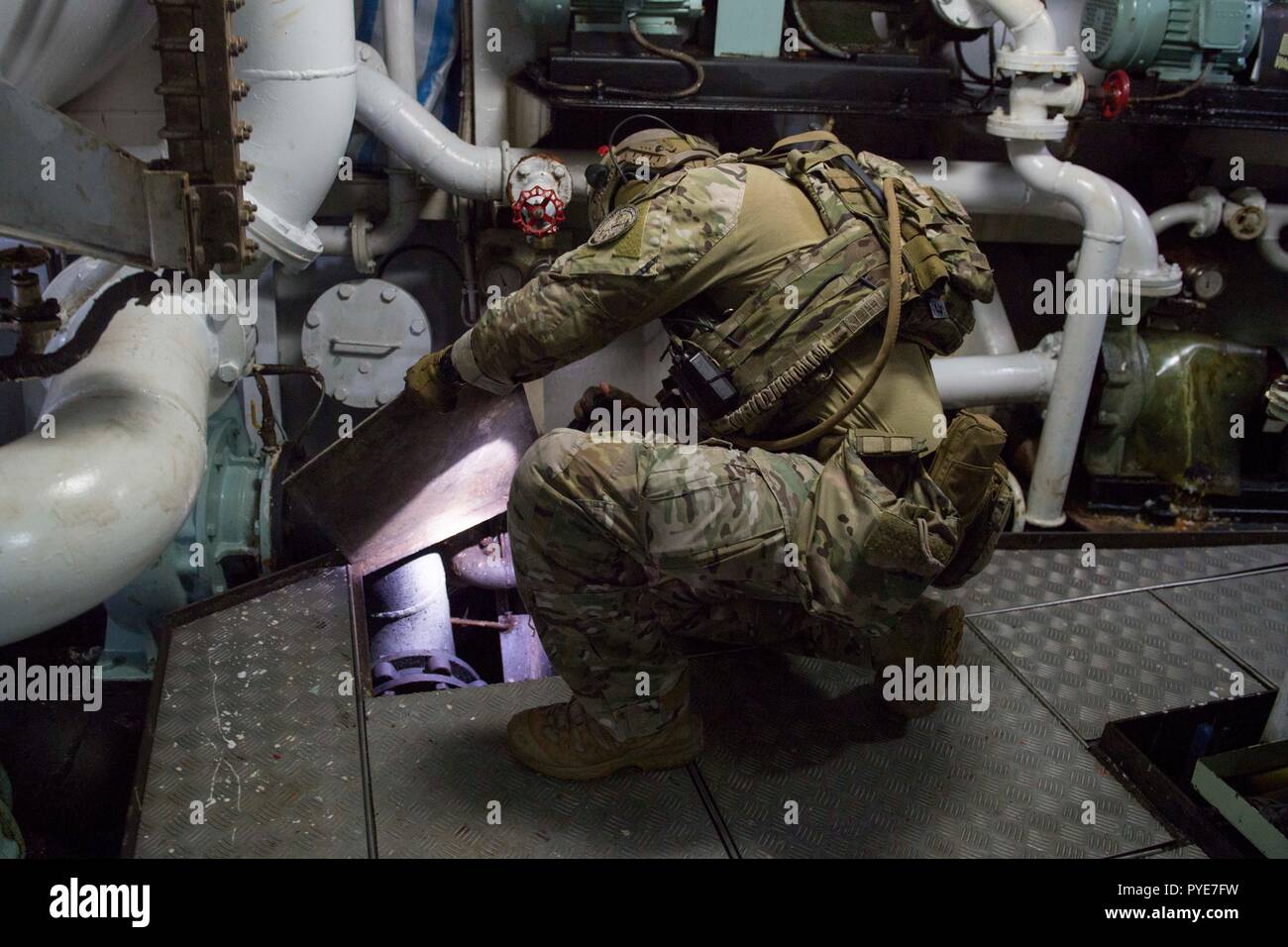 Pacifico occidentale (ott. 21, 2018) una costa Guardsman di U.S. La guardia costiera della applicazione della legge il distacco 107, imbarcato a bordo Arleigh Burke-class guidato-missile destroyer USS Shoup (DDG 86), ispeziona i tubi nel vano motore di un peschereccio durante un'Oceania la sicurezza marittima iniziativa (OMSI) Imbarco missione nel Pacifico occidentale ott. 21, 2018. Il programma di Omsi è un Segretario del programma di difesa sfruttando il Dipartimento della Difesa beni in transito attraverso il territorio della regione ad aumentare la protezione di litorale marittimo della consapevolezza di dominio, in ultima analisi a supporto della sua maritime le operazioni di polizia in Oceania. (U.S. Foto Stock