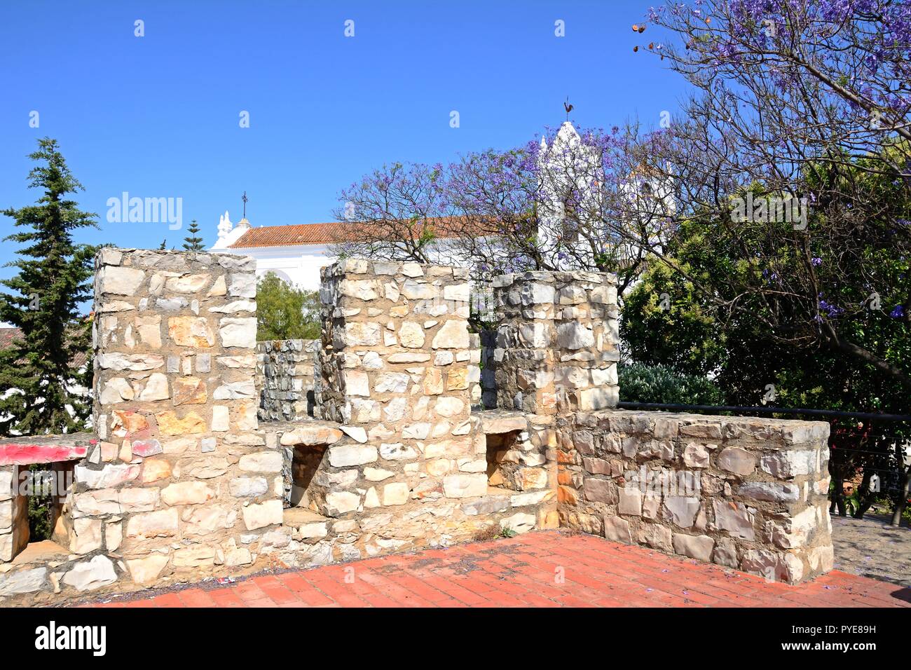 Vista sul castello di merlature con St Marys chiesa (Igreja de Santa Maria do Castelo) verso la parte posteriore, Tavira, Algarve, Portogallo, dell'Europa. Foto Stock