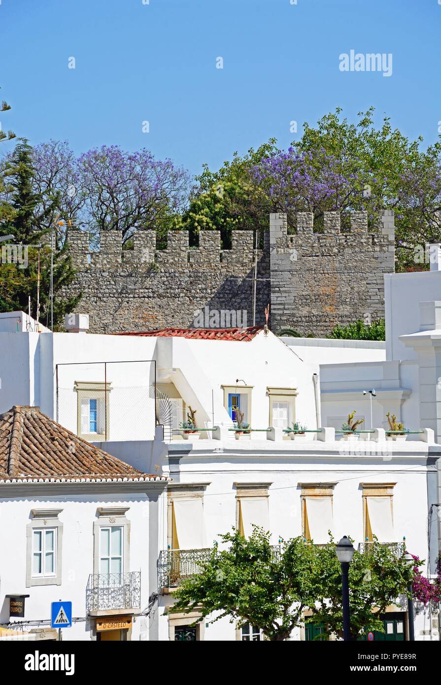 Vista in elevazione degli edifici della città con il castello merlature alla parte posteriore, Tavira, Algarve, Portogallo, dell'Europa. Foto Stock