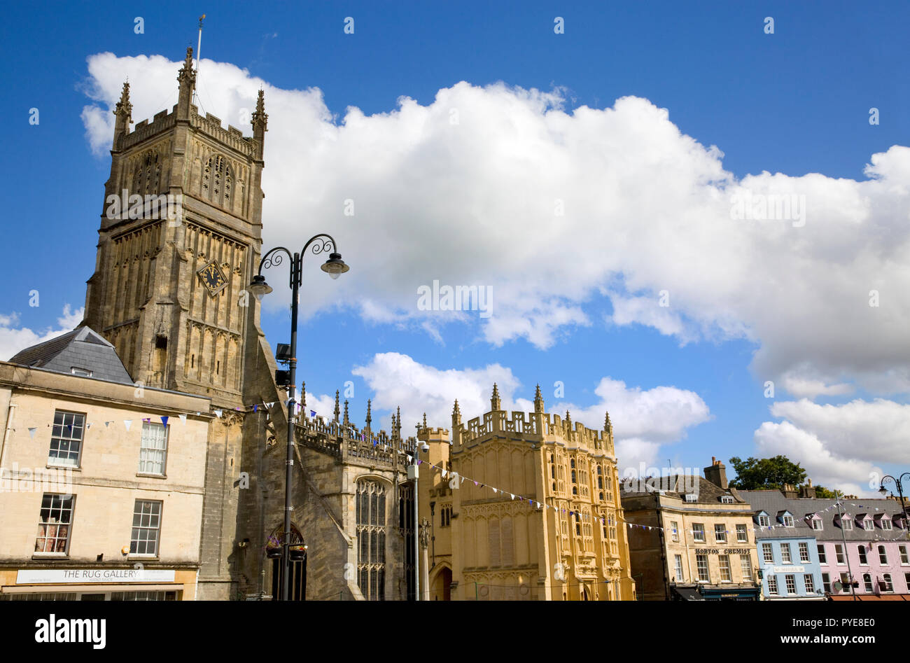 Ampia vista della chiesa di San Giovanni Battista e gli edifici vicini, luogo di mercato, Cirencester, Gloucestershire, Inghilterra Foto Stock