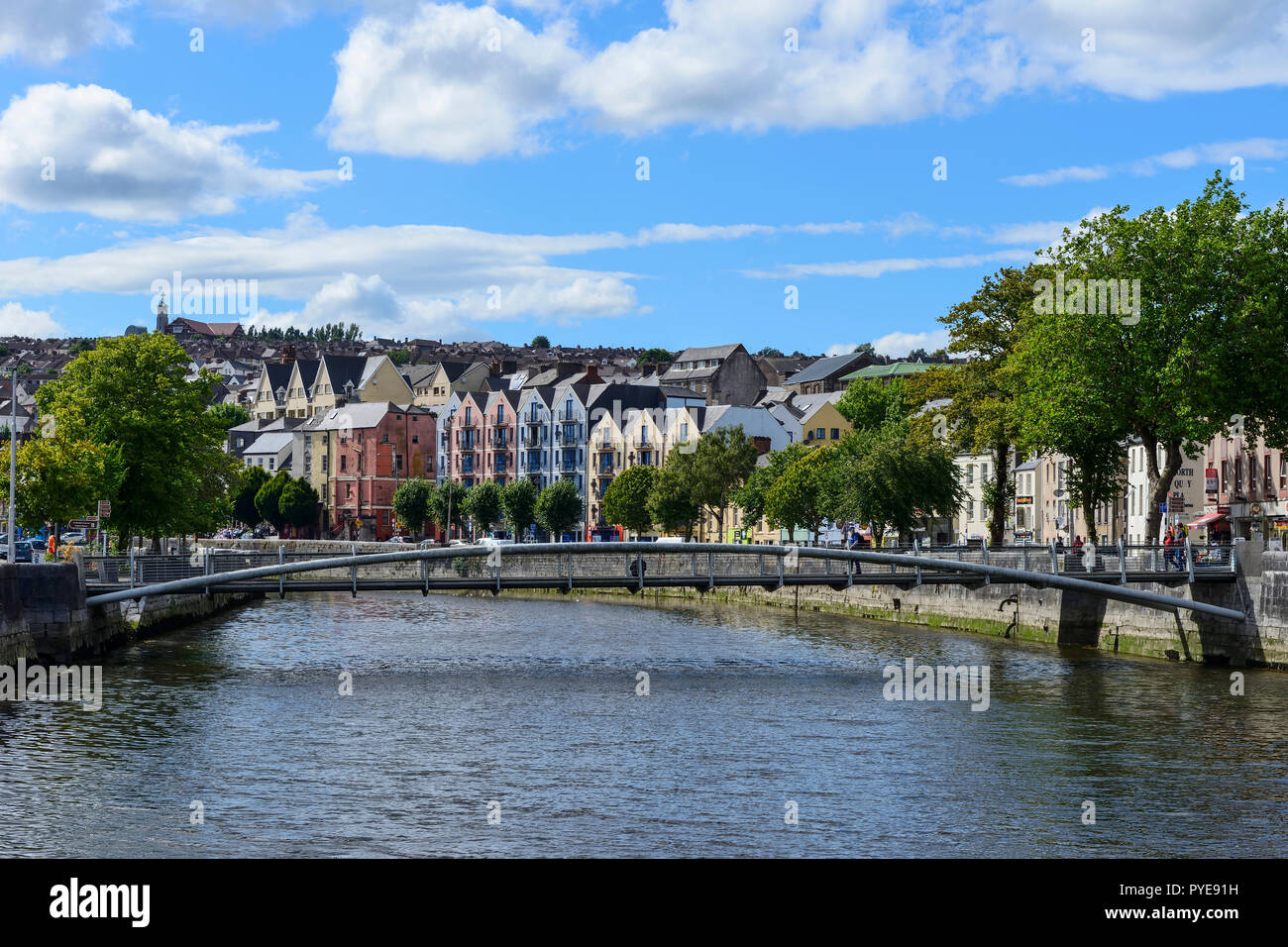 Passerella Pedonale sul fiume Lee con edificio colorato su Papi Quay in background, Cork, nella contea di Cork, Repubblica di Irlanda Foto Stock
