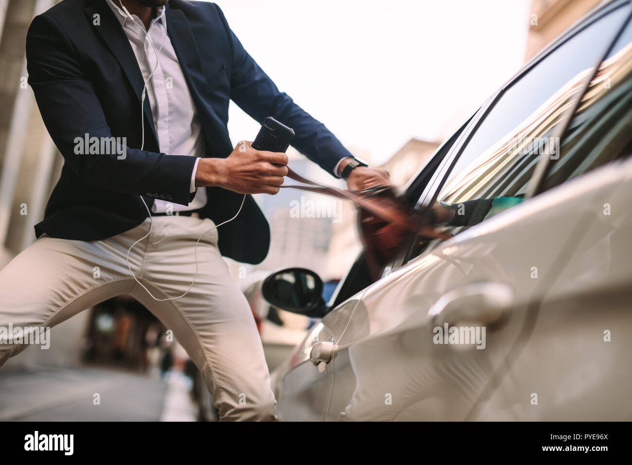 Imprenditore tirando fuori la sua borsetta da un'auto. Uomo in tuta telefono azienda parlando fuori la sua borsa da una finestra auto sulla strada. Foto Stock