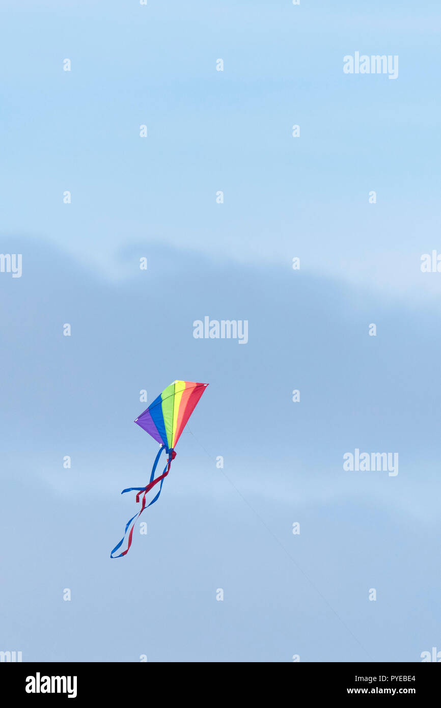 Un colorato aquilone volare contro un cielo blu. Foto Stock