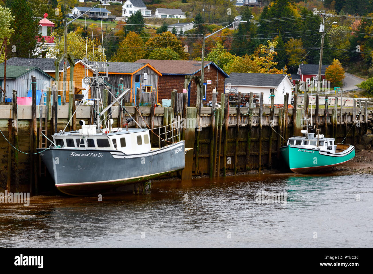 Costa est di barche da pesca ormeggiate al dock a bassa marea nel villaggio di Saint Martins New Brunswick Canada Foto Stock