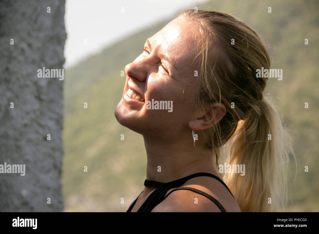 Ritratto di giovane donna bionda strizzare gli occhi al sole Foto Stock