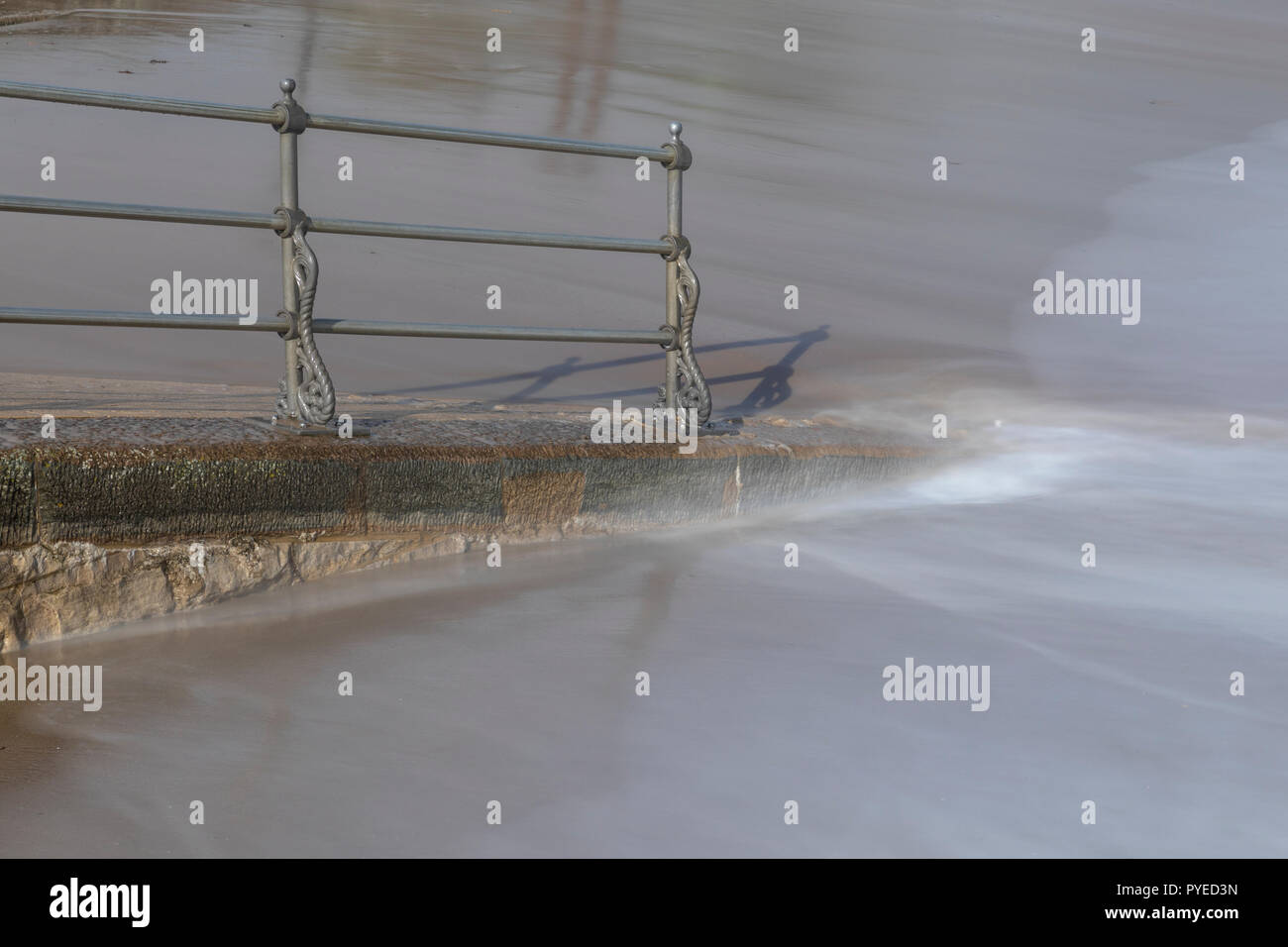 Misty lappatura di acqua in corrispondenza di una rampa di accesso per la sabbiosa spiaggia di Swanage Foto Stock