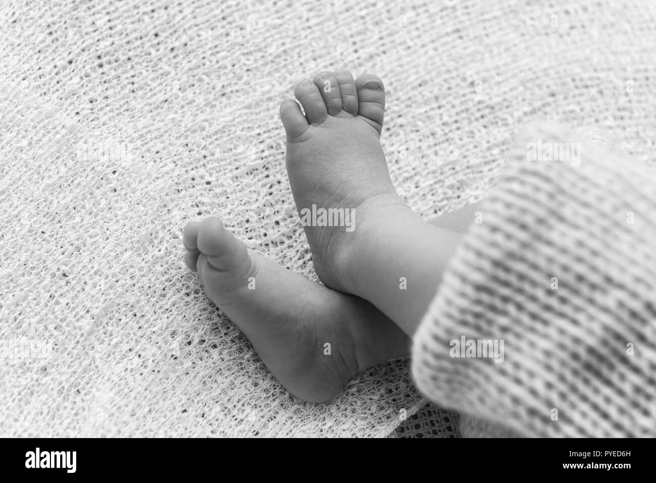 Primo piano di un neonato piedi con belle messa a fuoco selettiva. Concetto di congedo di maternità e tenerezza Foto Stock