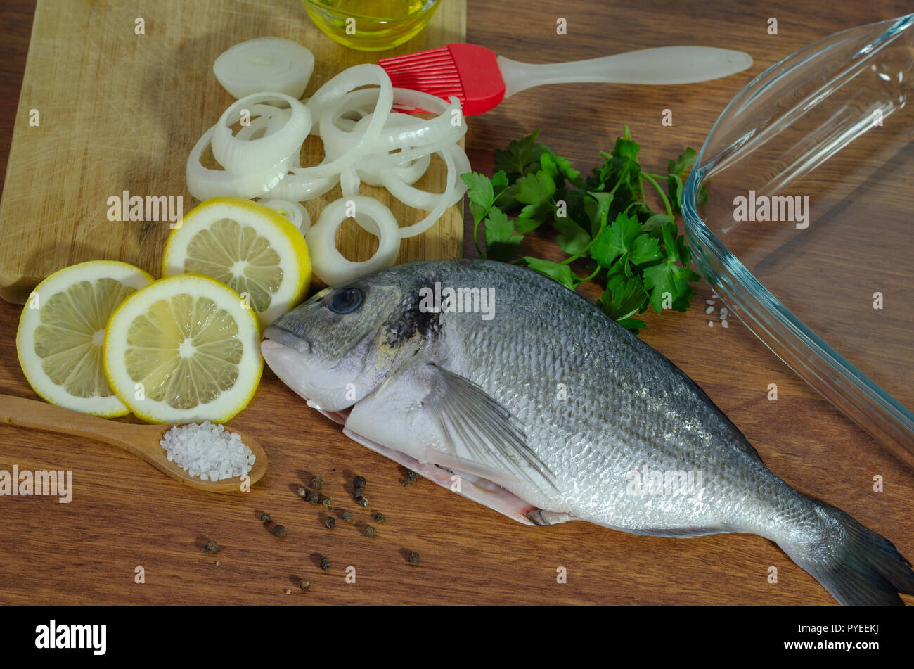 Crudo fresco branzino pesce sul tagliere di legno Foto Stock