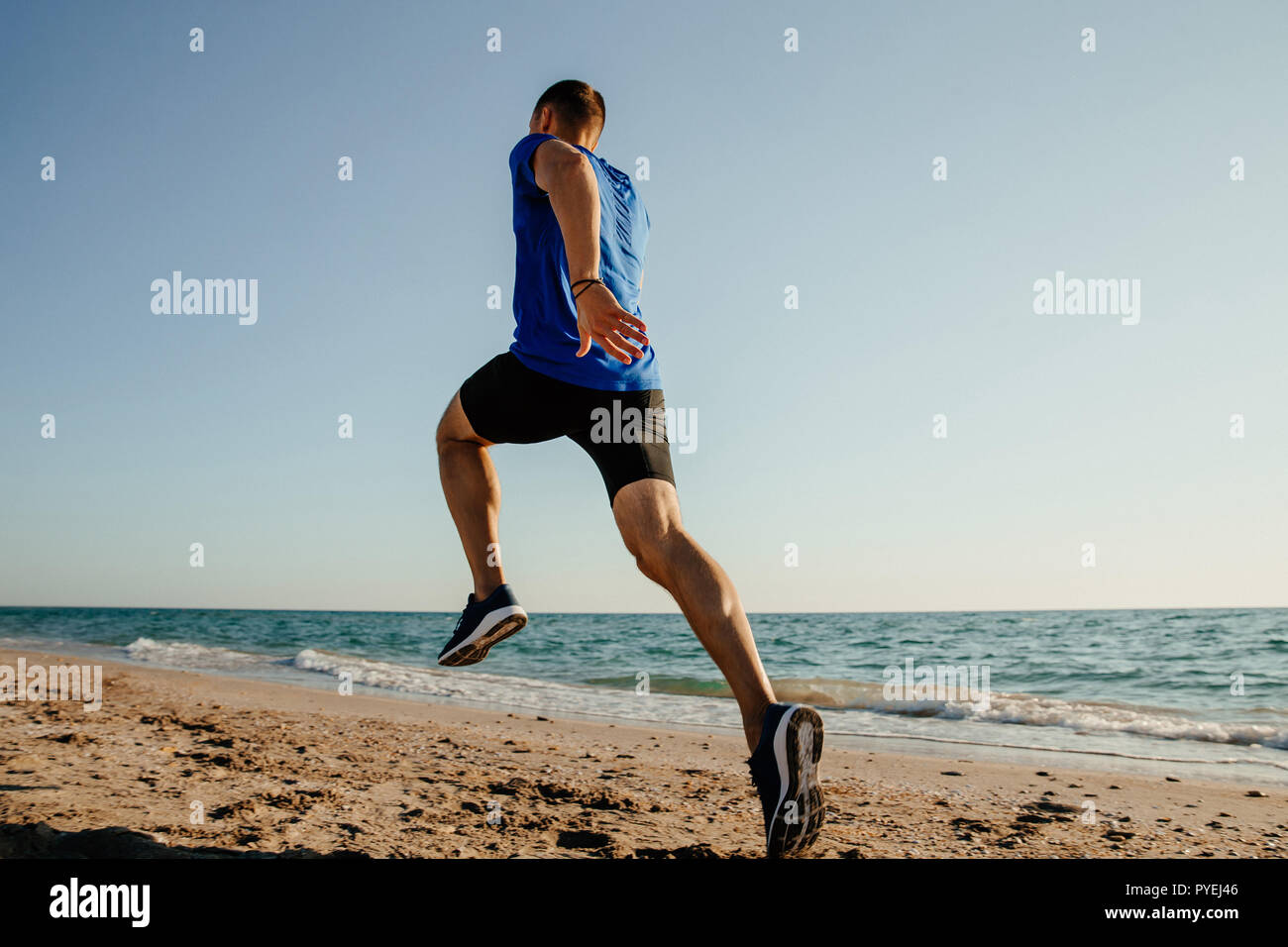 Retro con uomo che corre runner sulla spiaggia di sabbia di mare Foto Stock
