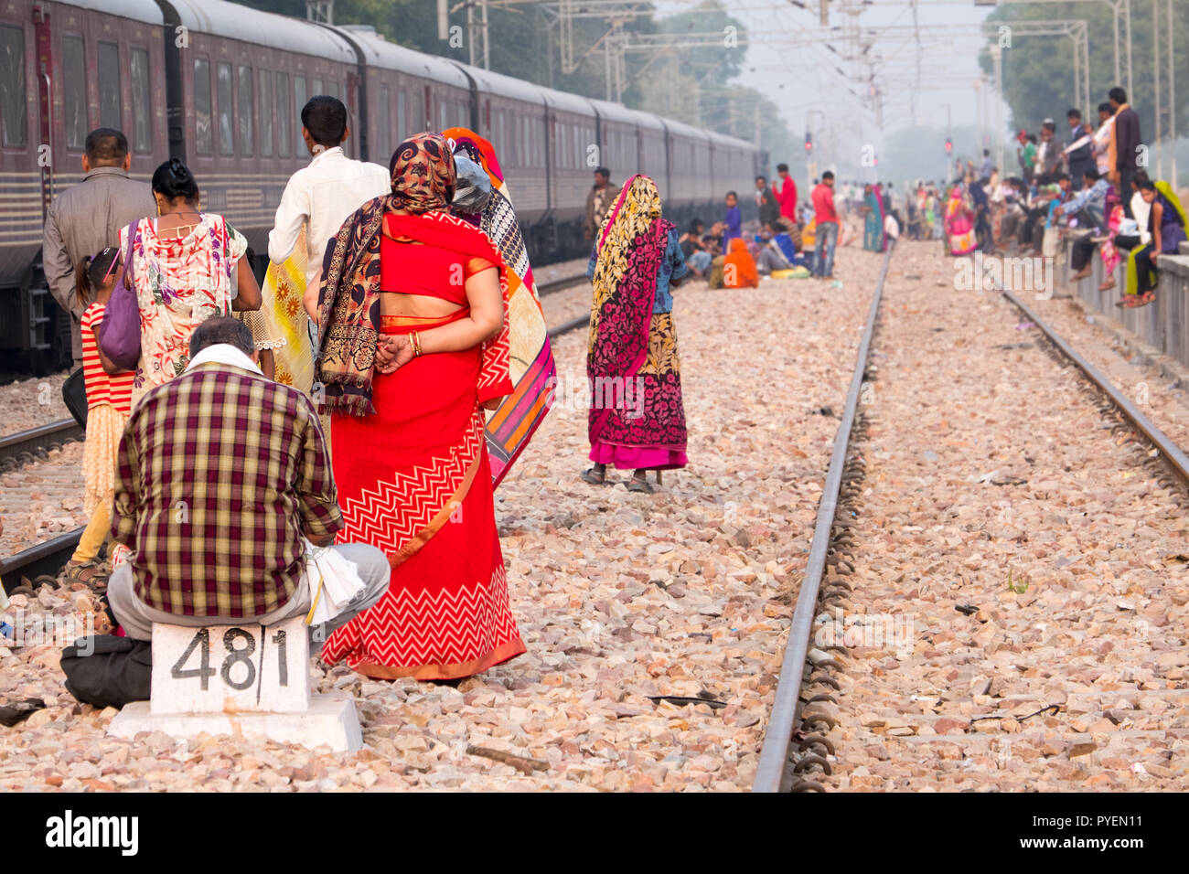 Indian i passeggeri in attesa sui binari di un treno in arrivo, India Foto Stock
