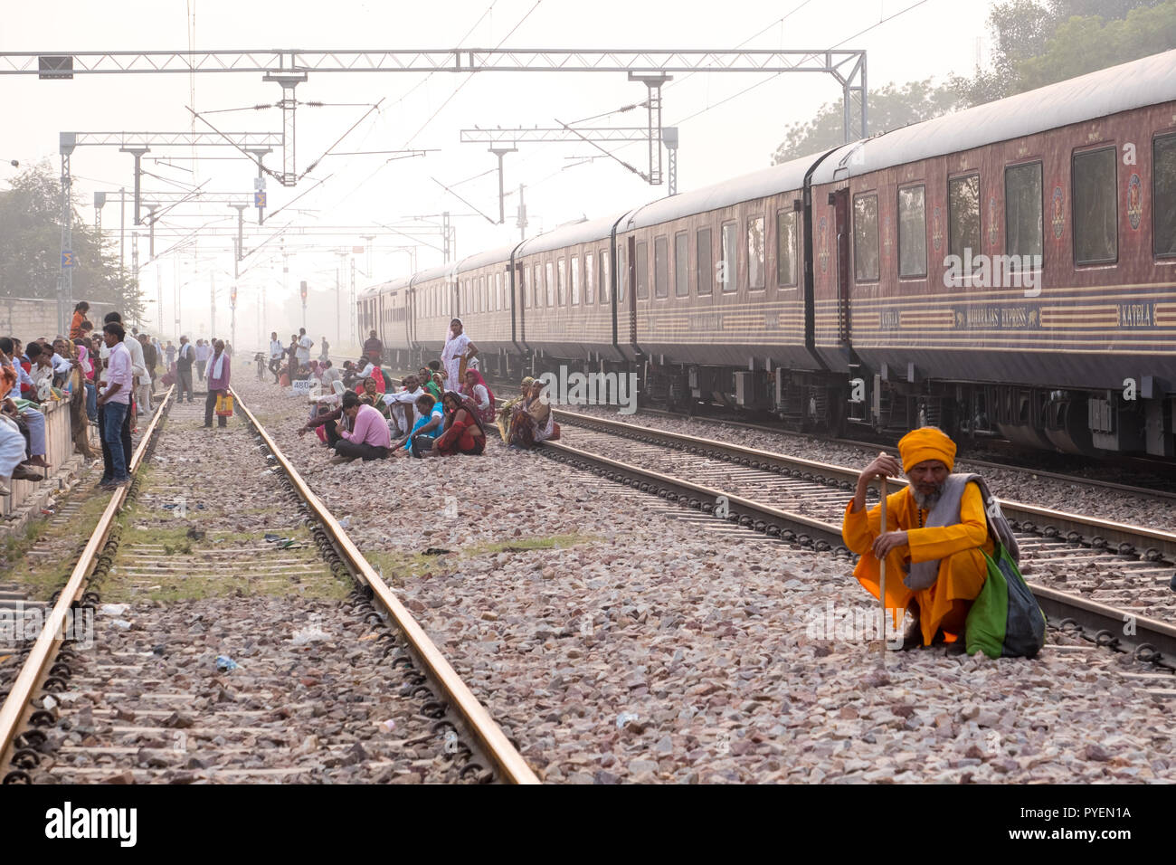 Indian i passeggeri in attesa sui binari di un treno in arrivo, India Foto Stock