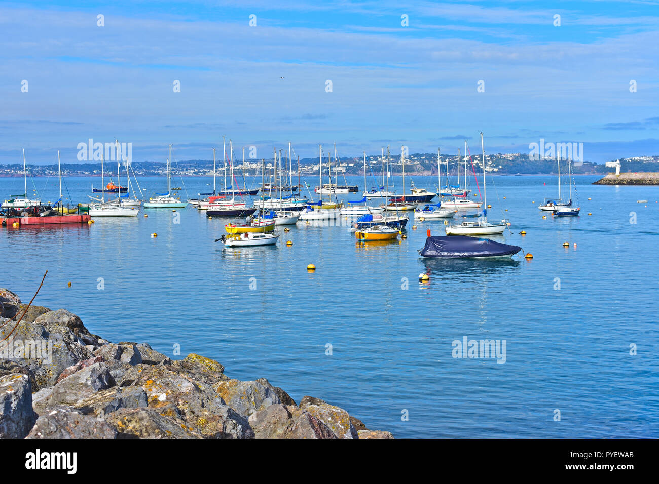 Una tranquilla vista attraverso l'ingresso al porto Birxham verso Torquay in distanza. Brixham, Devon, Inghilterra, Regno Unito Foto Stock