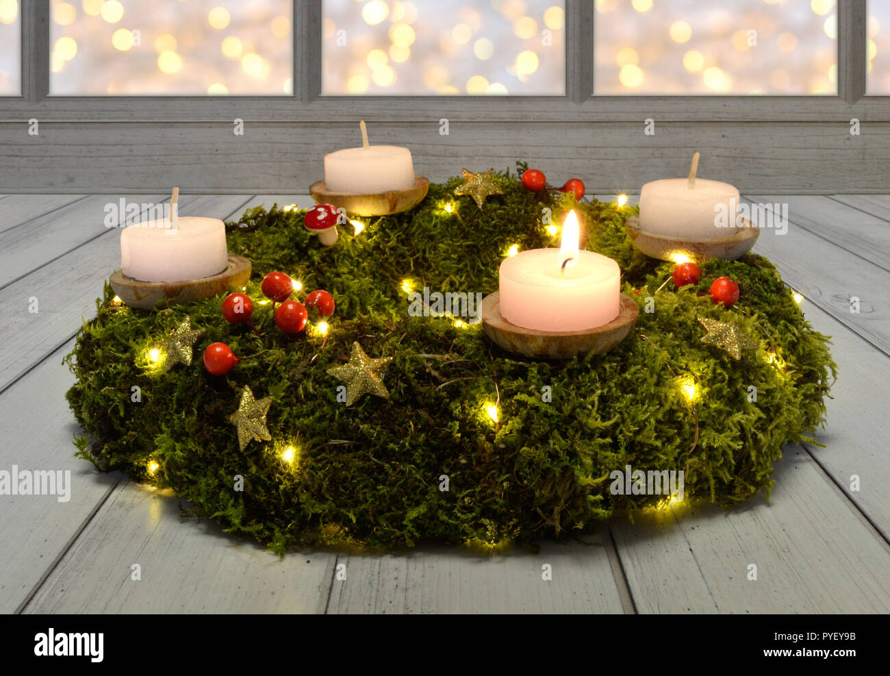 Avvento ghirlanda di Natale candele sera legno scuro moss Foto Stock