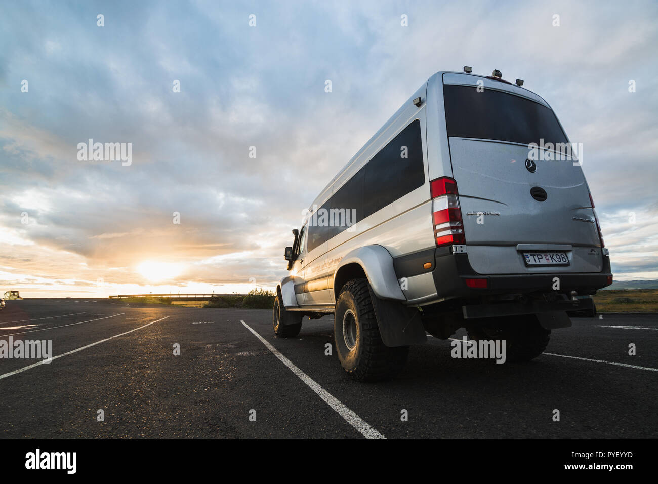 Super jeep bus con grandi ruote su strada durante il tramonto in Islanda. Foto Stock