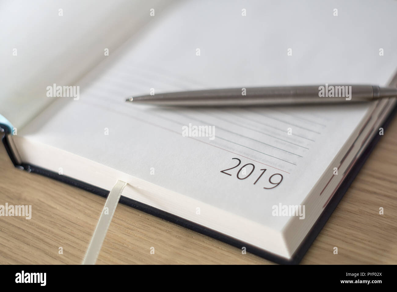 Anno Nuovo 2019 office organizer Calendario, smartphone, bicchieri e sliver penna a sfera sulla scrivania in legno. Immagine con copia spazio. Messa a fuoco selettiva. Foto Stock