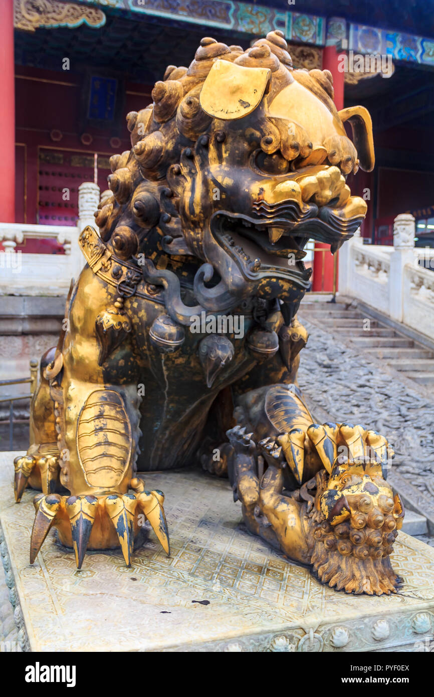 Close up tradizionale femmina dorato Imperial guardian lion, tenendo un bambino nella famosa città proibita a Pechino, Cina Foto Stock