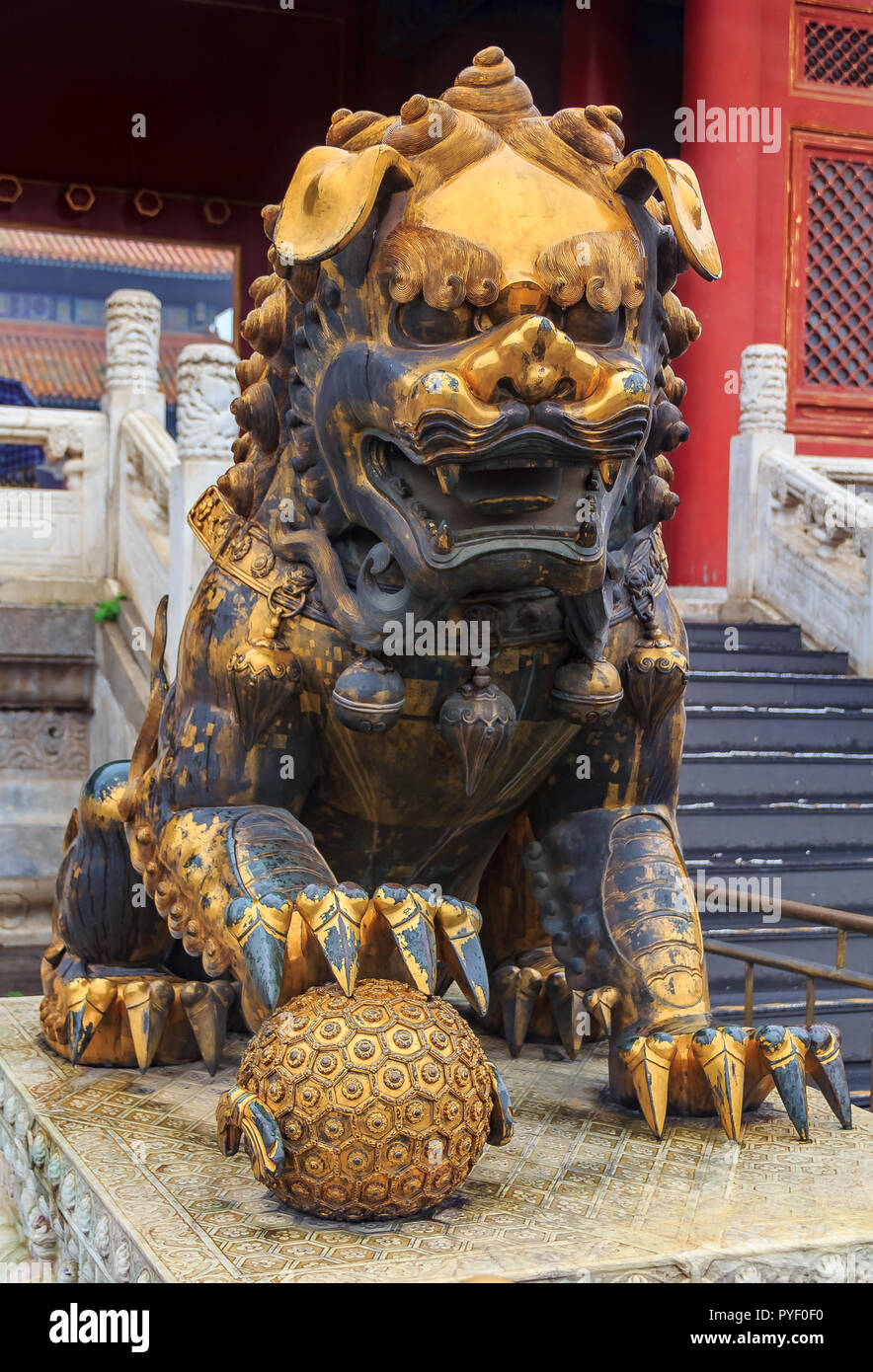 Close up di un tradizionale maschio dorati custode imperiale Leone con il simbolo del mondo tenutasi uder la zampata nella famosa Città Proibita di Pechino, Chi Foto Stock