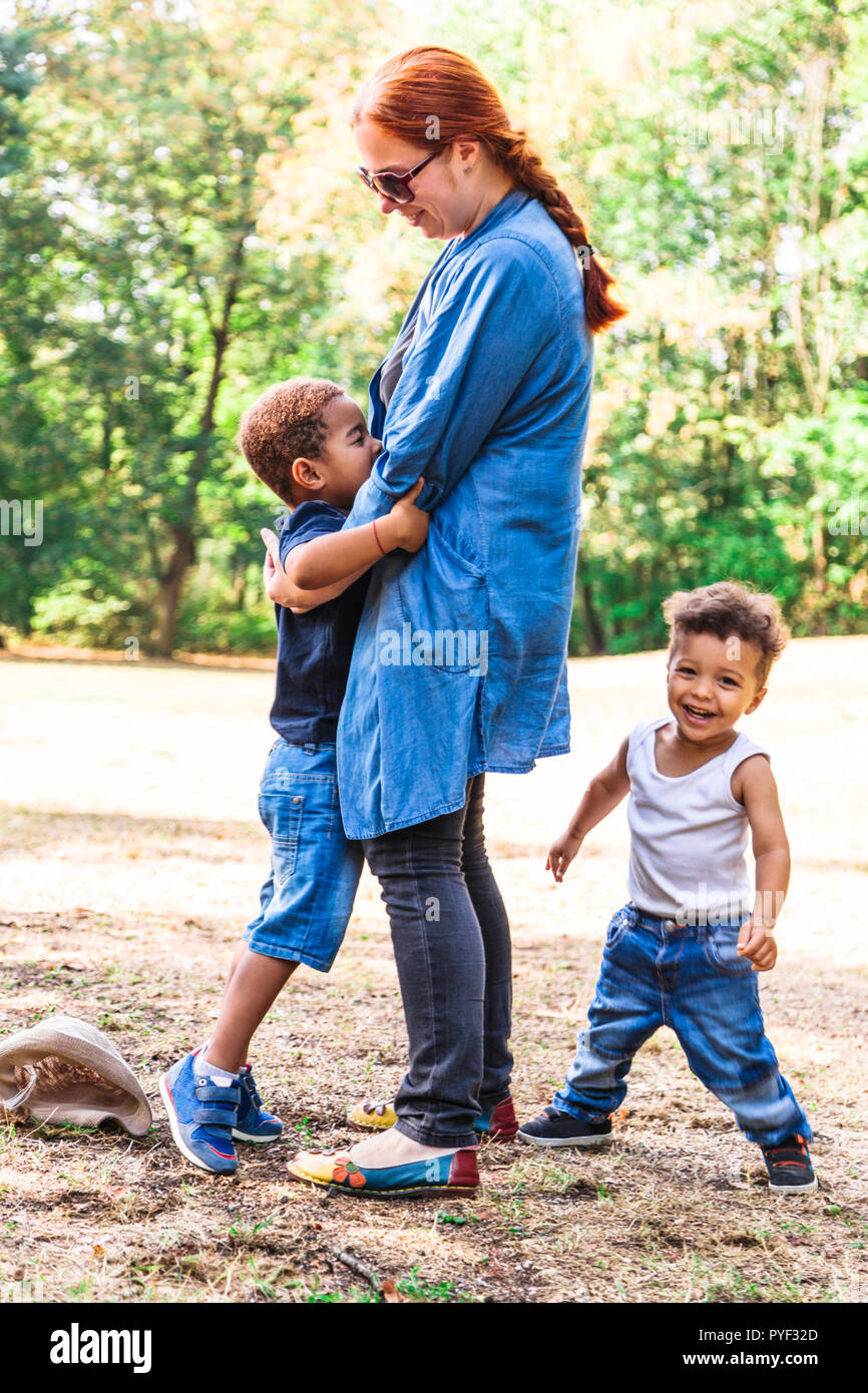 Internazionale di madre di famiglia e afro o latino-americana fratelli giocando in posizione di parcheggio Foto Stock