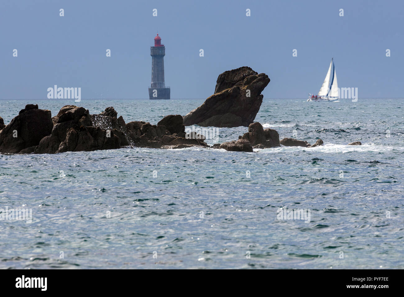 La Jument faro e una barca a vela, isola di Ushant, Bretagna Francia Foto Stock