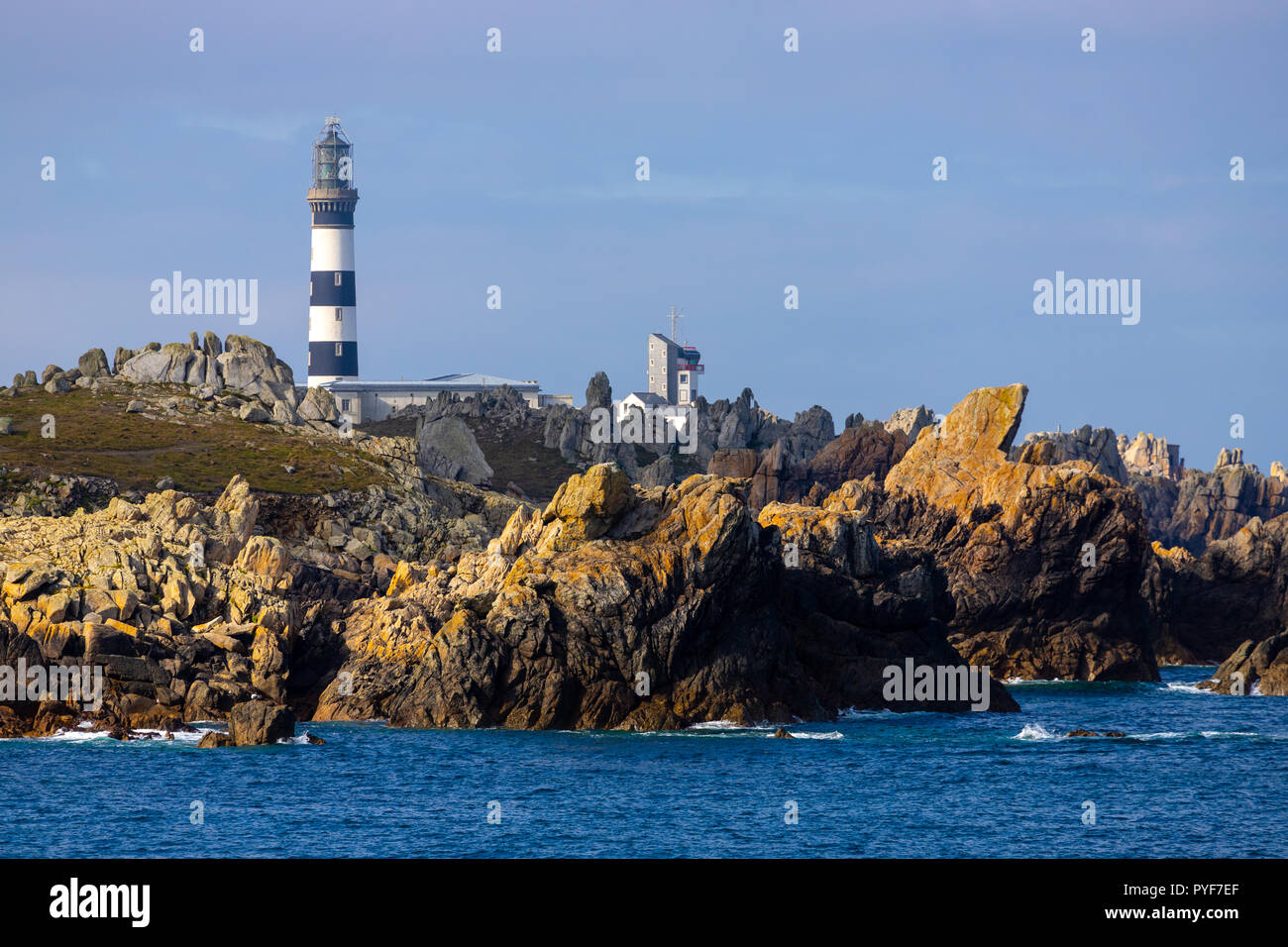 Il Creach faro sul nitido e la costa rocciosa di Ushant island, Brittany, Francia Foto Stock