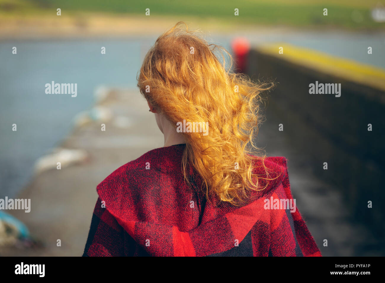 Redhead donna passeggiate in spiaggia Foto Stock