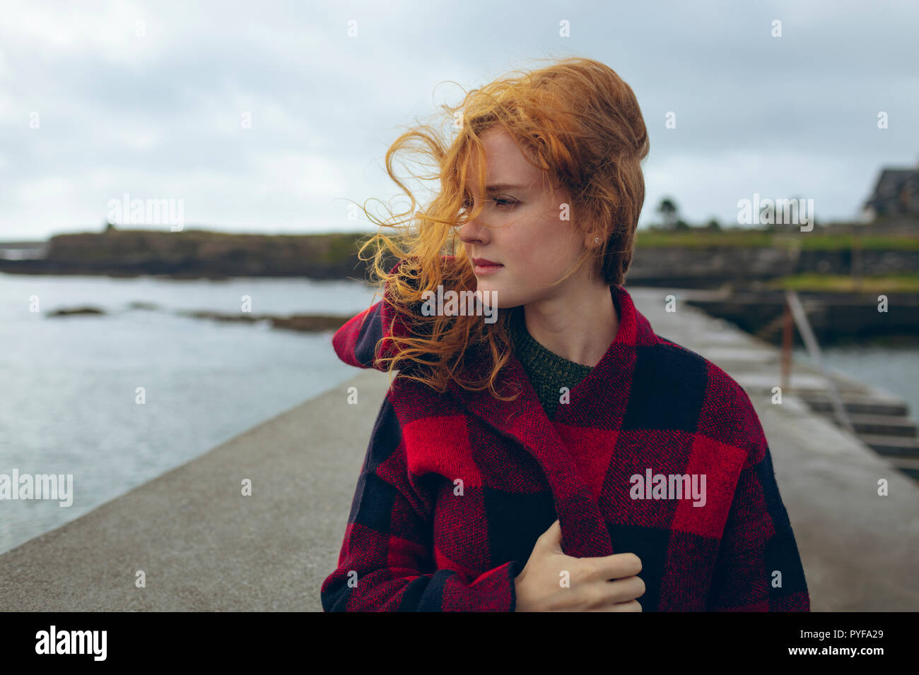 Redhead woman standing in spiaggia Foto Stock