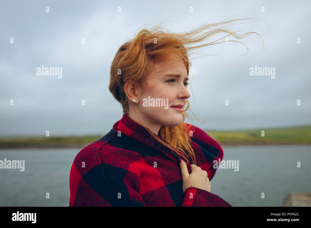 Redhead woman standing in spiaggia Foto Stock