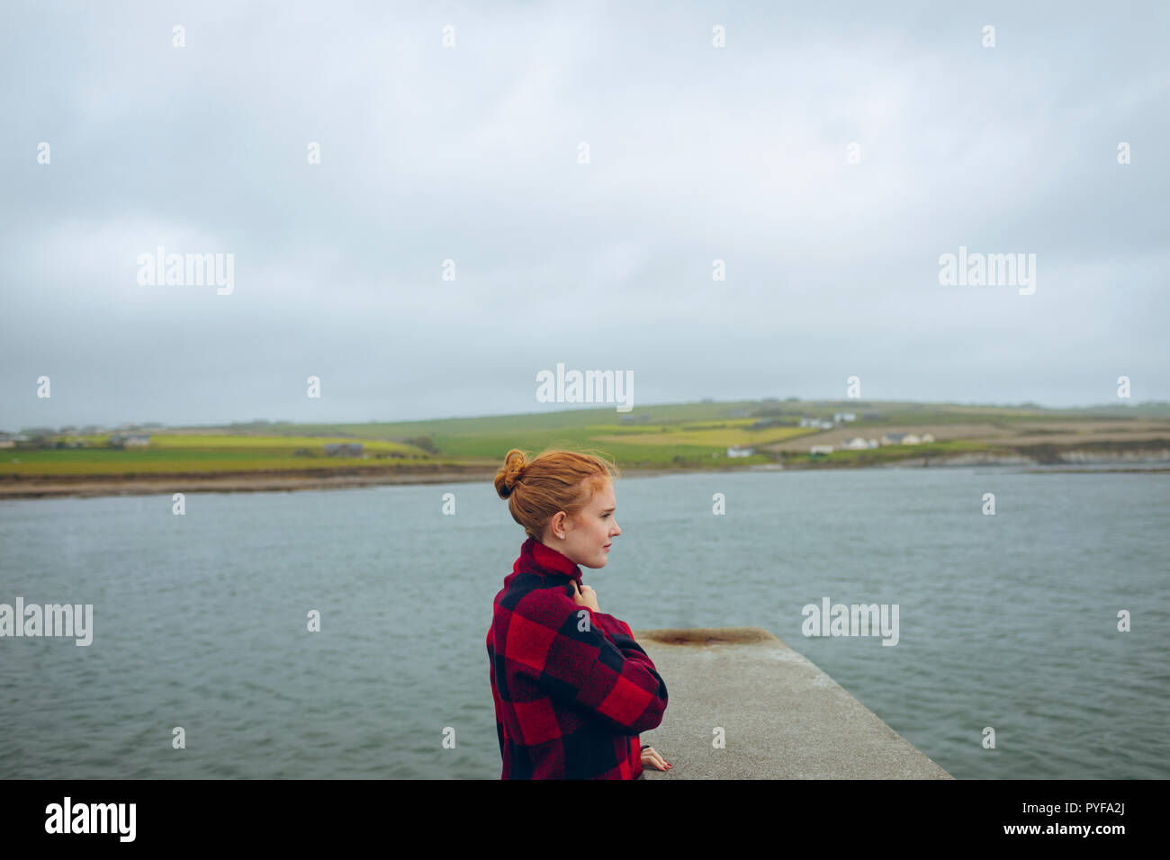 Redhead woman standing in spiaggia Foto Stock