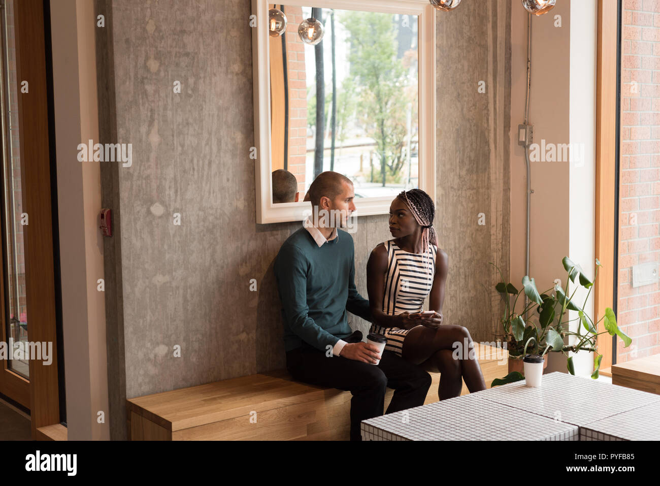 Paio di interagire gli uni con gli altri in cafe Foto Stock